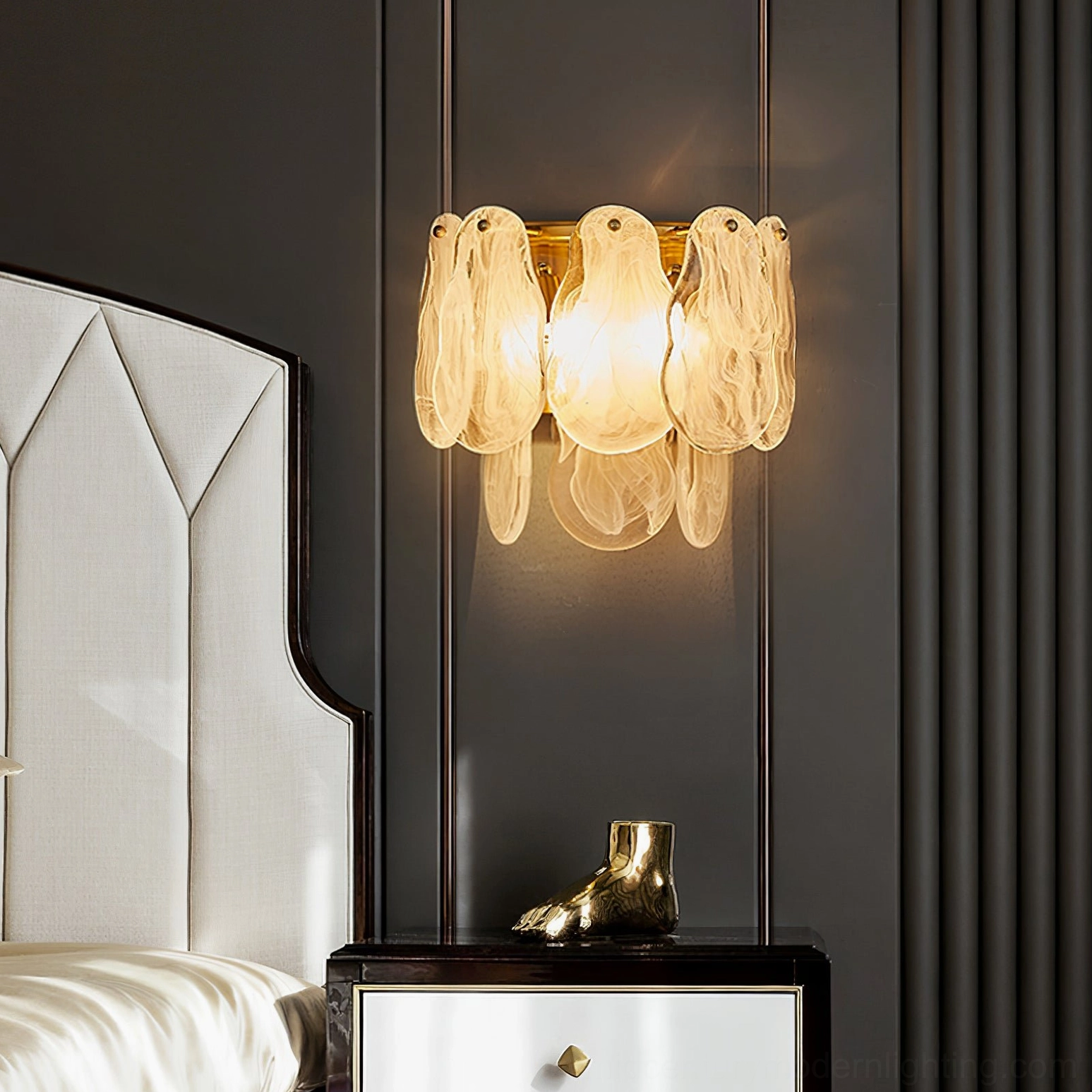 Frosted cloud glass wall lamp close-up showing intricate petal-shaped glass shades with warm light glow and brass hardware