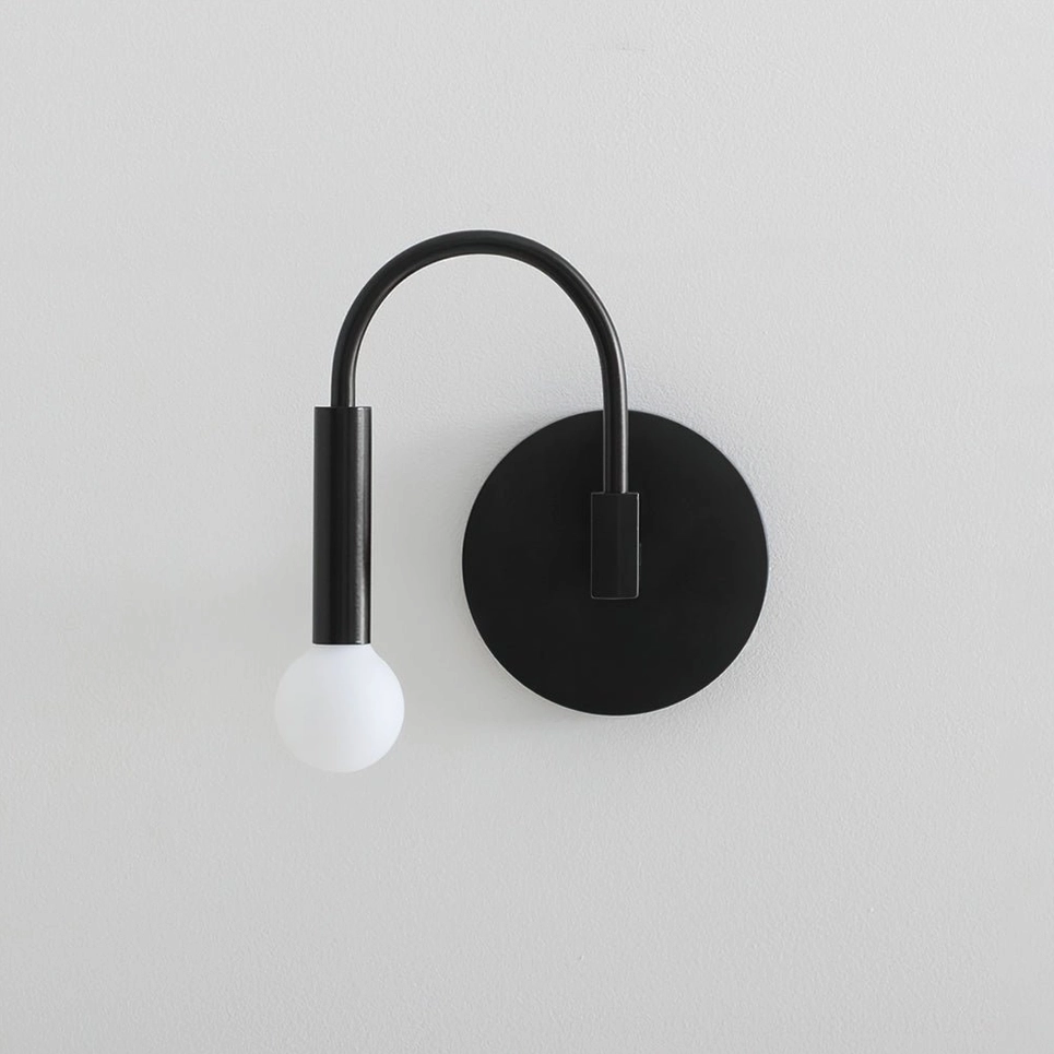 Single arch wall sconce with frosted glass globe and curved metal support arm