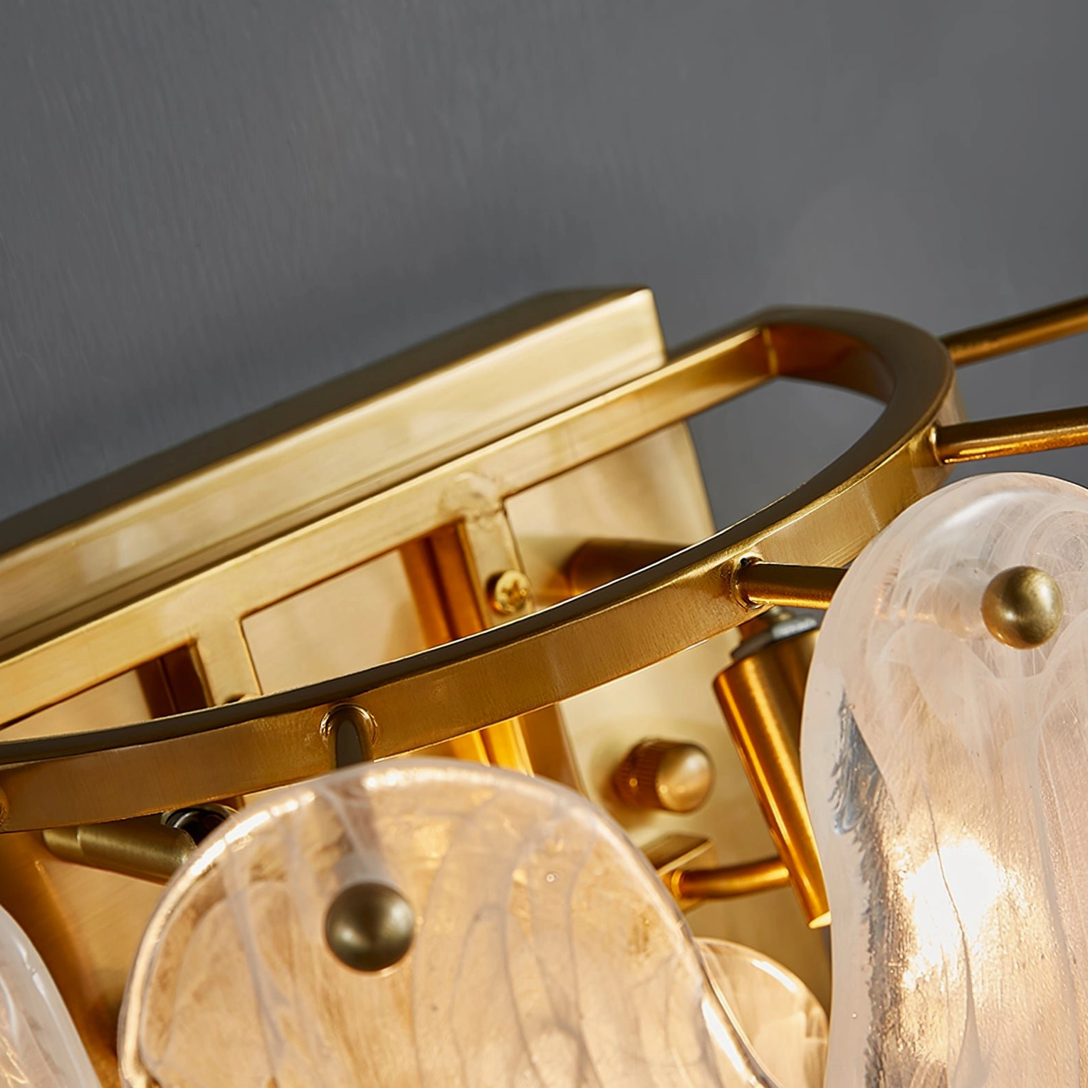 Frosted cloud glass wall sconce with warm illumination highlighting glass texture and brass metalwork in contemporary interior