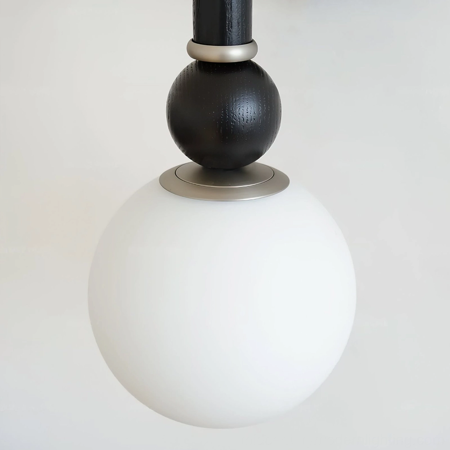 Globe assembly close-up showing frosted glass sphere, textured black details, and silver metal components