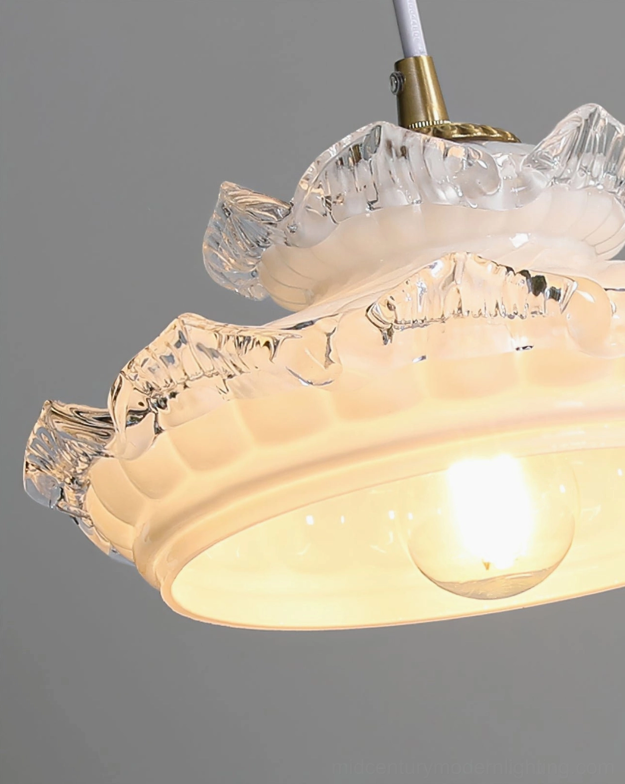 Close-up detail view of frosted milk glass pendant with intricate ruffled texture and exposed bulb