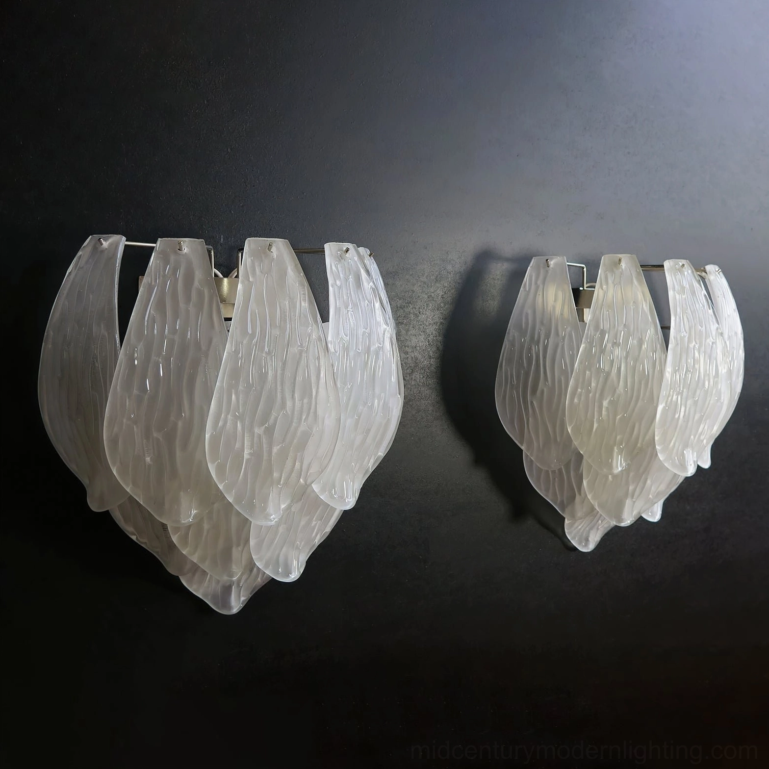 Frosted petal sconce demonstrating scale and proportion as statement light fixture on bedroom wall