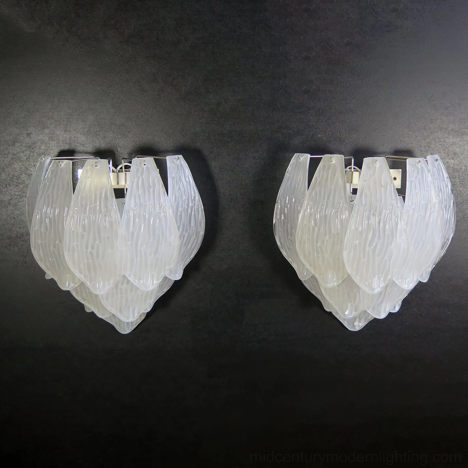 Frosted petal wall sconce illuminated in modern interior setting showing ambient lighting aesthetic effect