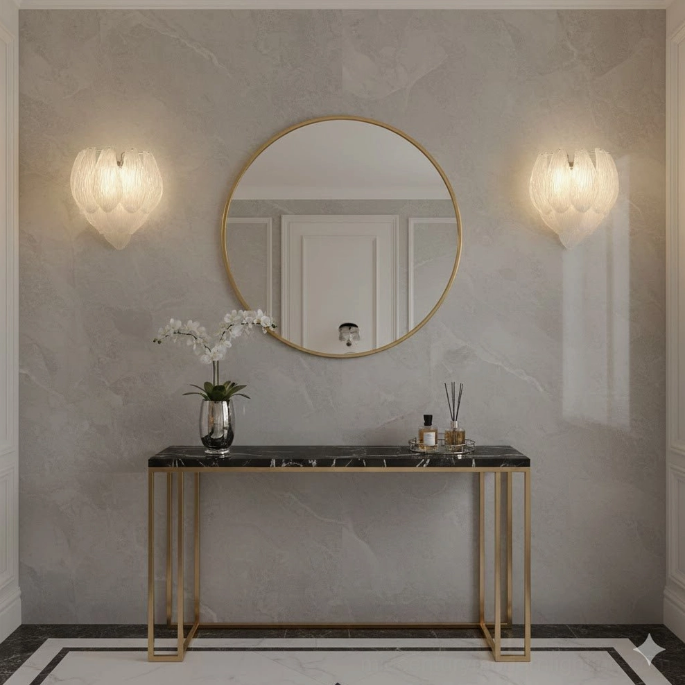 Twin frosted petal sconces flanking gold-framed round mirror on marble console table in modern luxury entryway