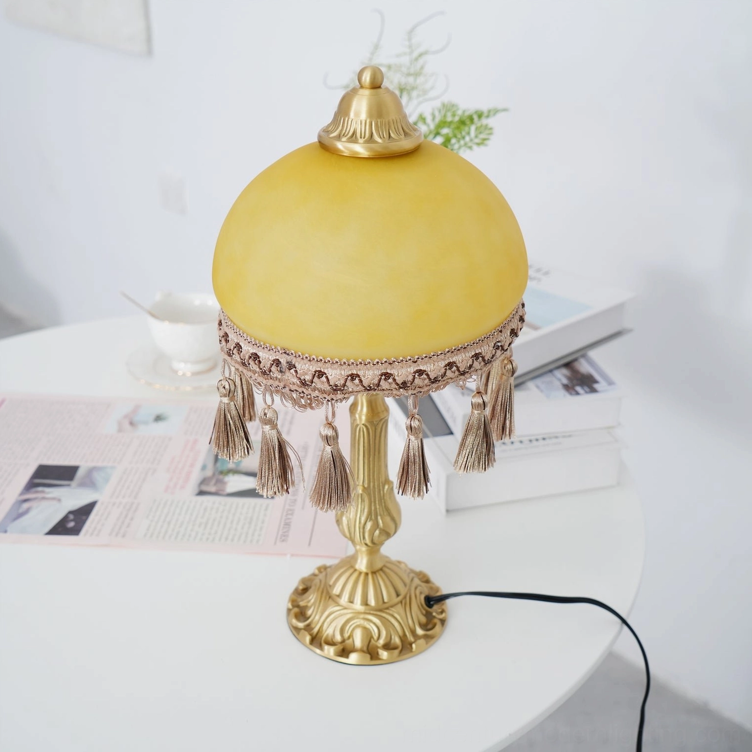 Brass tassel table lamp showing frosted glass shade and tassel embellishment design