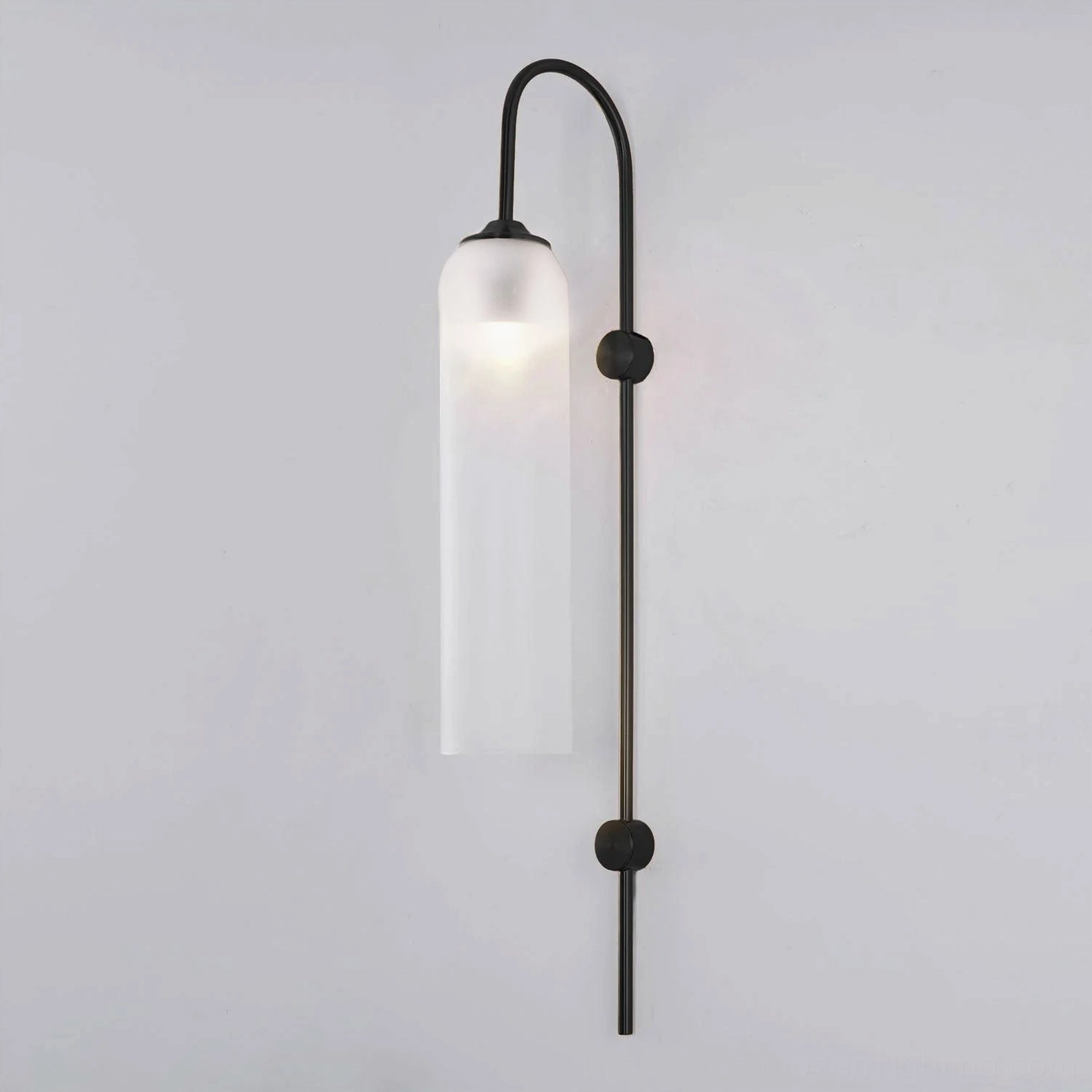 Frosted white cylindrical glass wall sconce with sleek metal frame architectural lighting solution