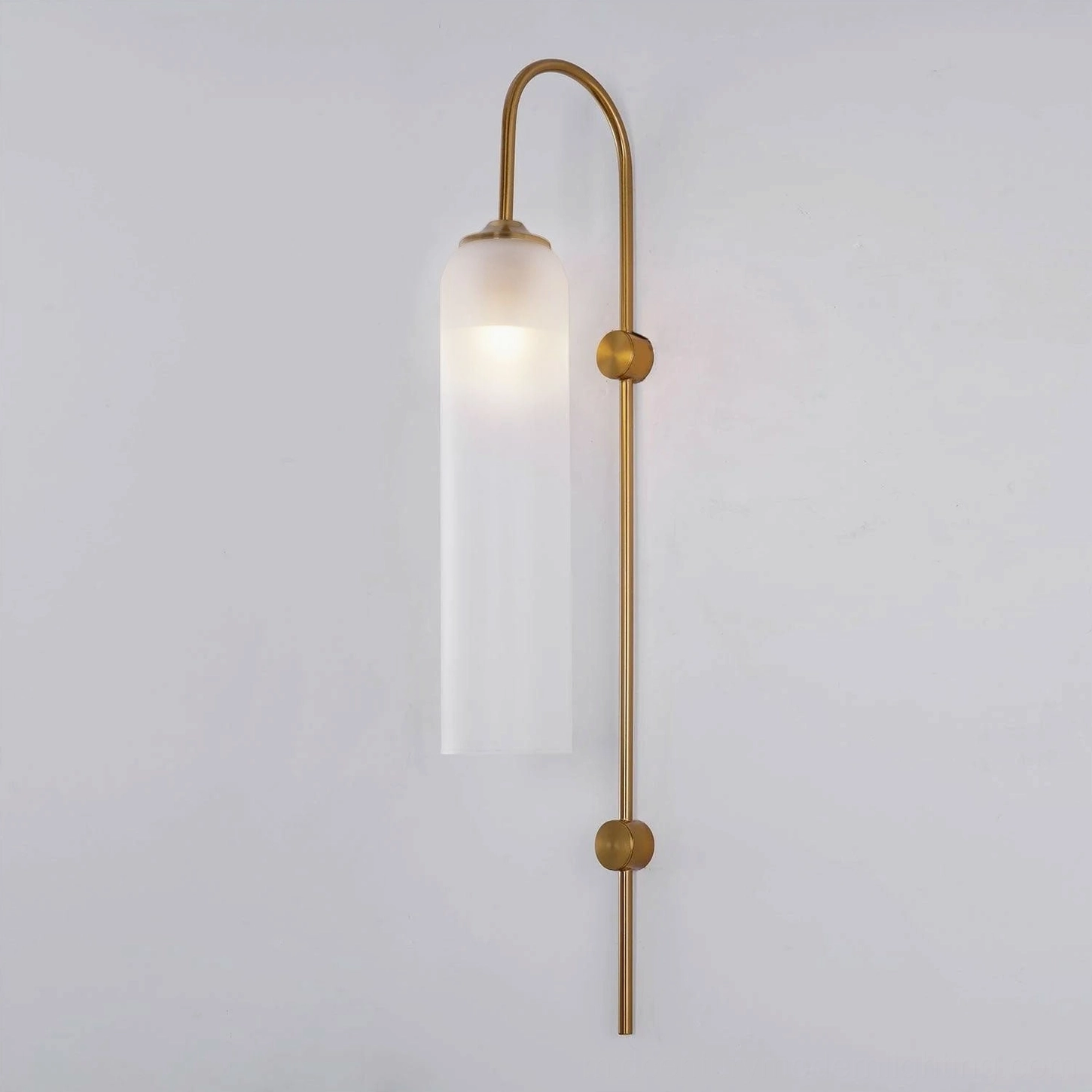 Frosted white glass wall sconce with gold metal finish in sophisticated interior display