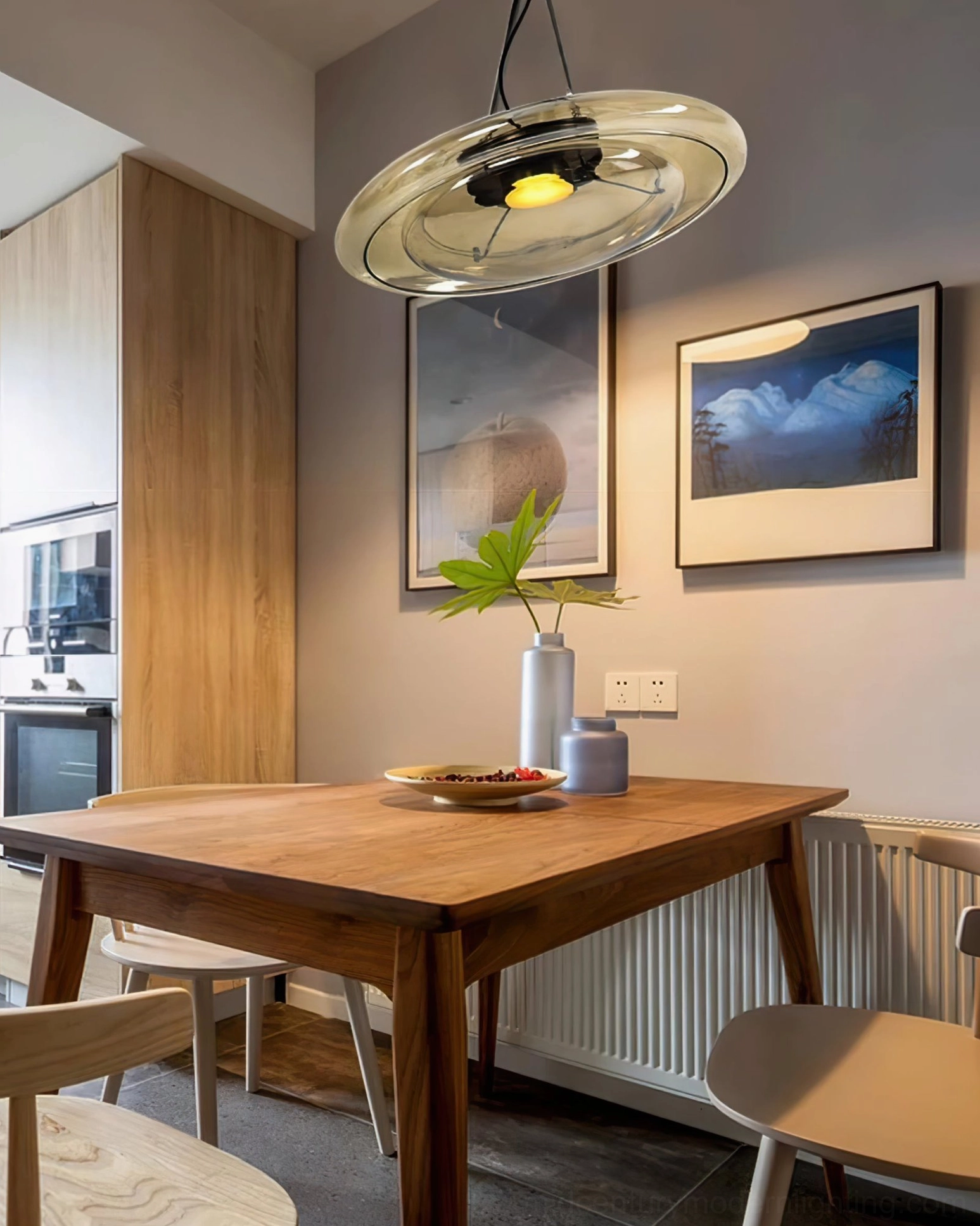 Futura glass pendant lamp suspended above wooden dining table in warm Nordic interior design setting