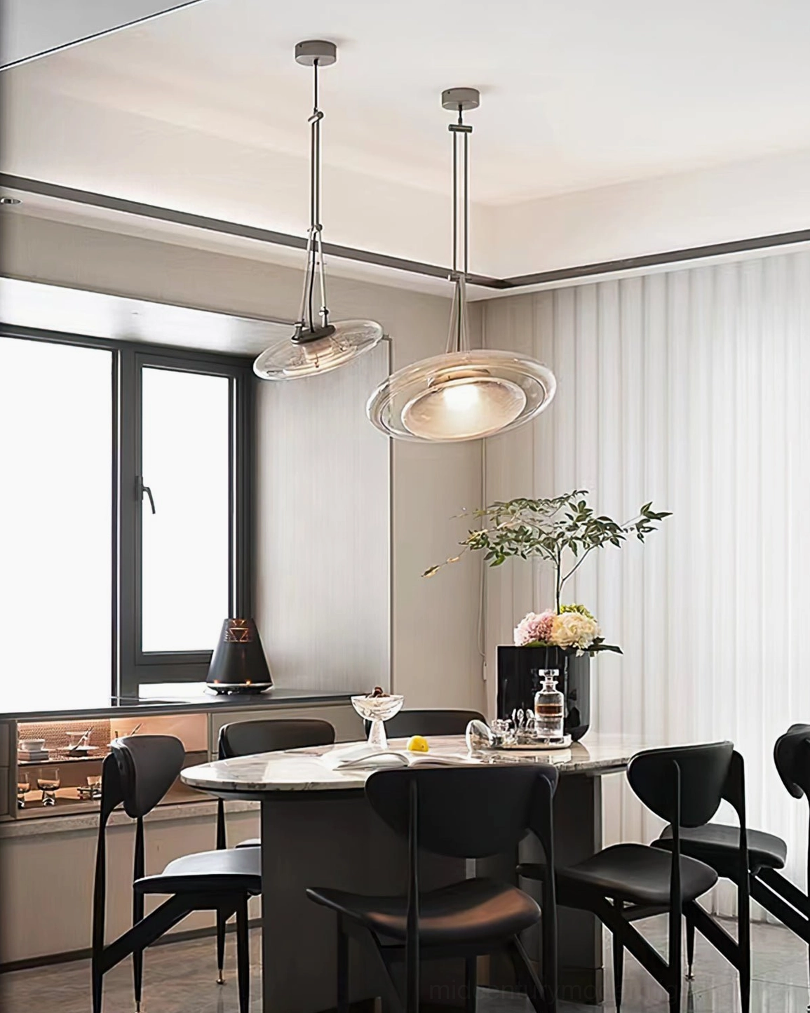 Two Futura pendant lamps illuminating modern dining table in warm contemporary kitchen setting
