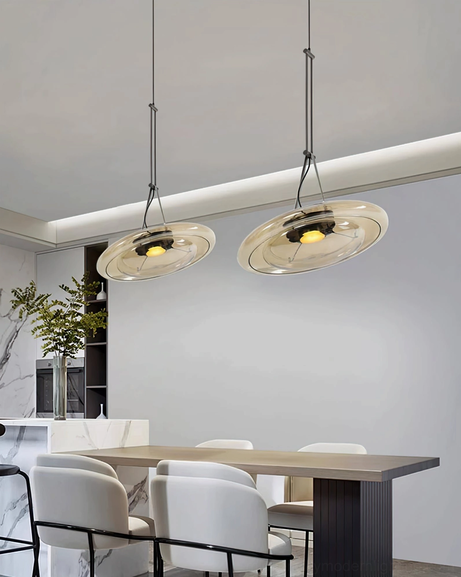 Dual Futura pendant lamps above long dining table with white modern chairs in minimalist interior
