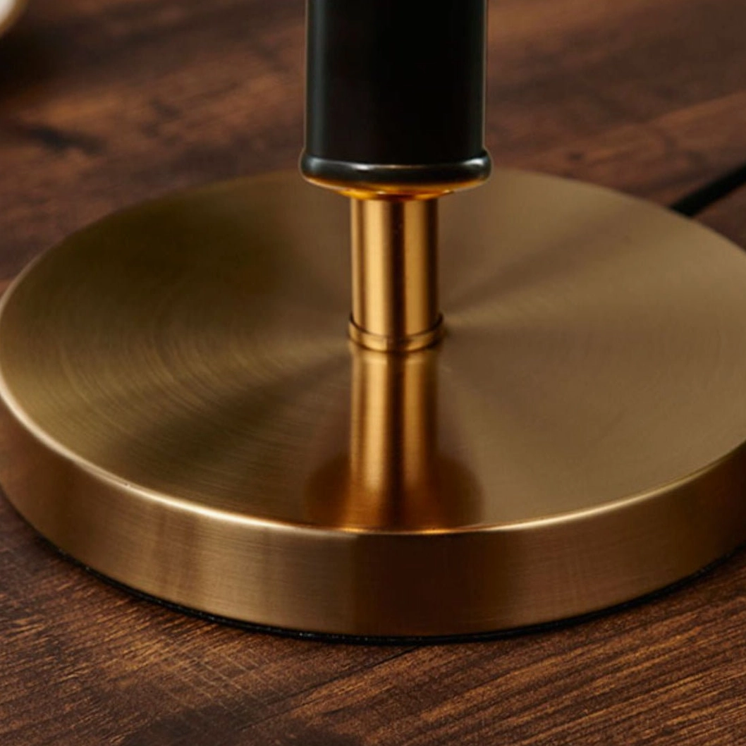 Lamp base close-up on wooden tabletop, solid brushed gold round base detail