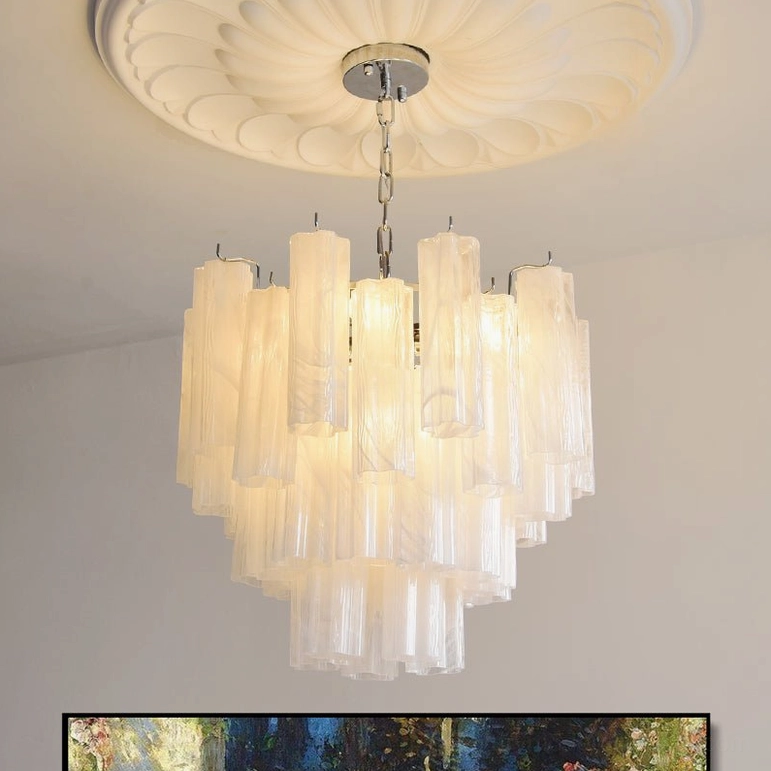 Off-white Gabriella tiered glass chandelier hanging in luxury residential space with romantic lighting ambiance