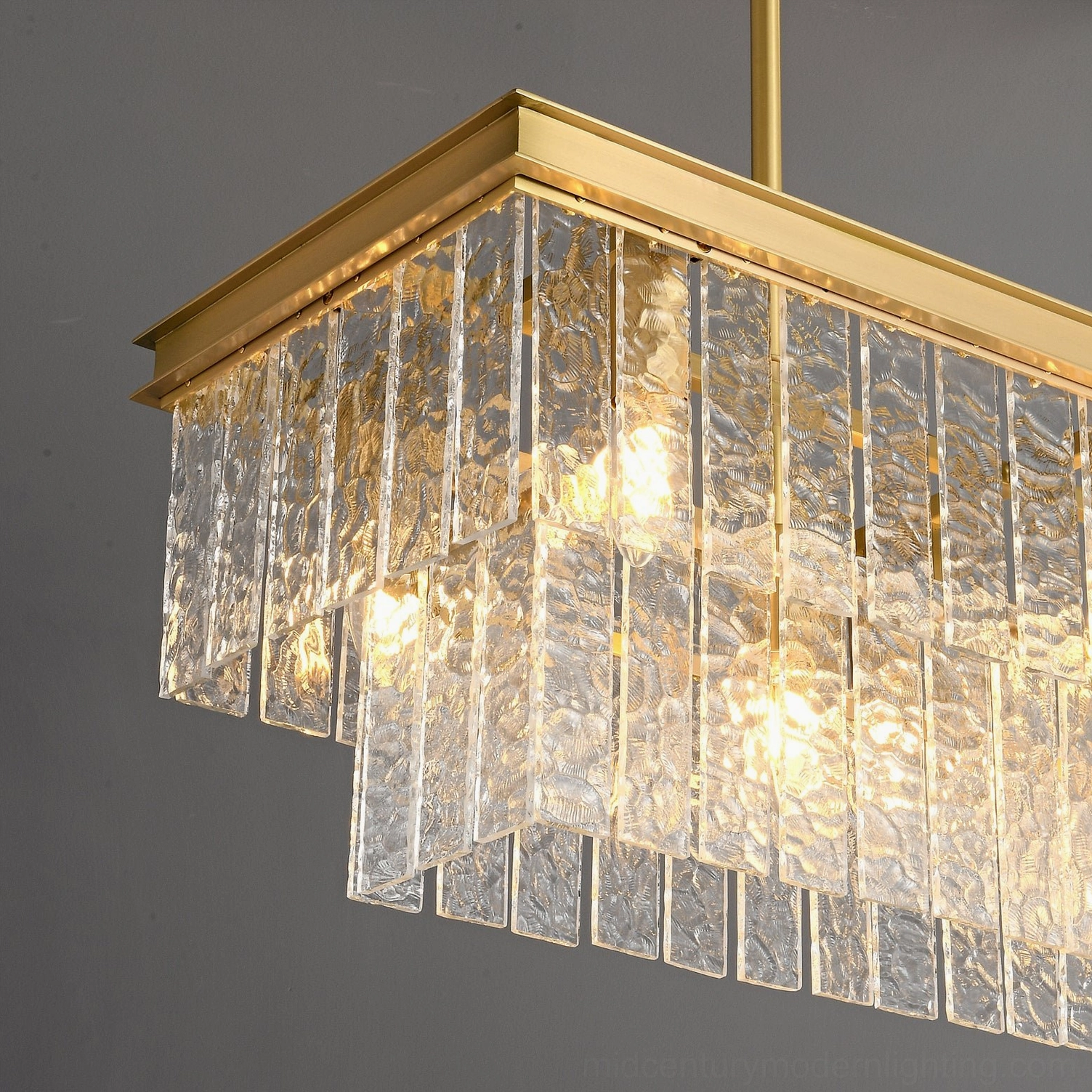 Extreme close-up of Gaia tiered chandelier emphasizing rippled glass texture and warm glowing lamp details