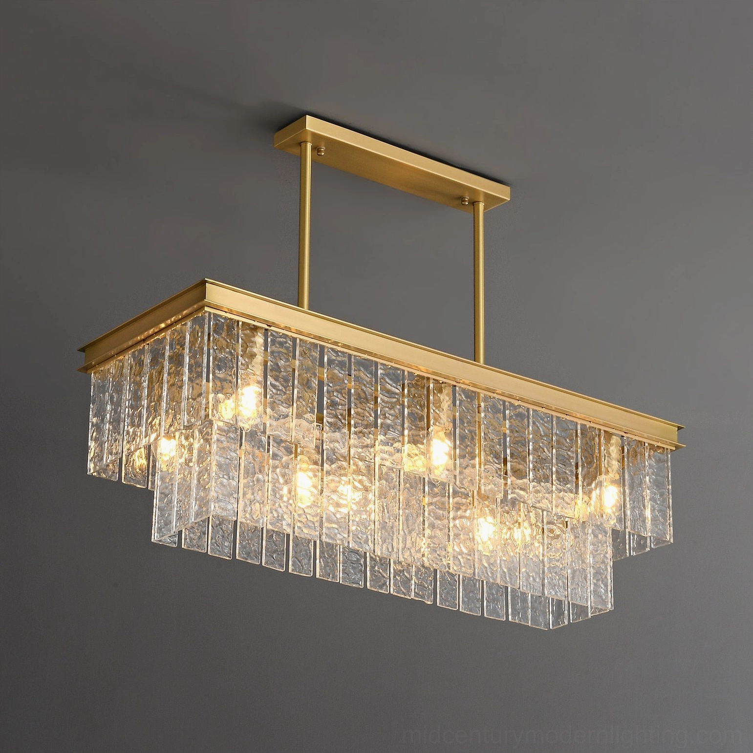 Rectangular tiered glass chandelier three-quarter front view displaying illuminated glass layers and metallic frame