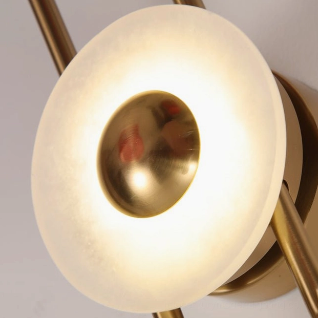 Gaia wall lamp close-up brass gold disc with frosted glass and ribbed metal