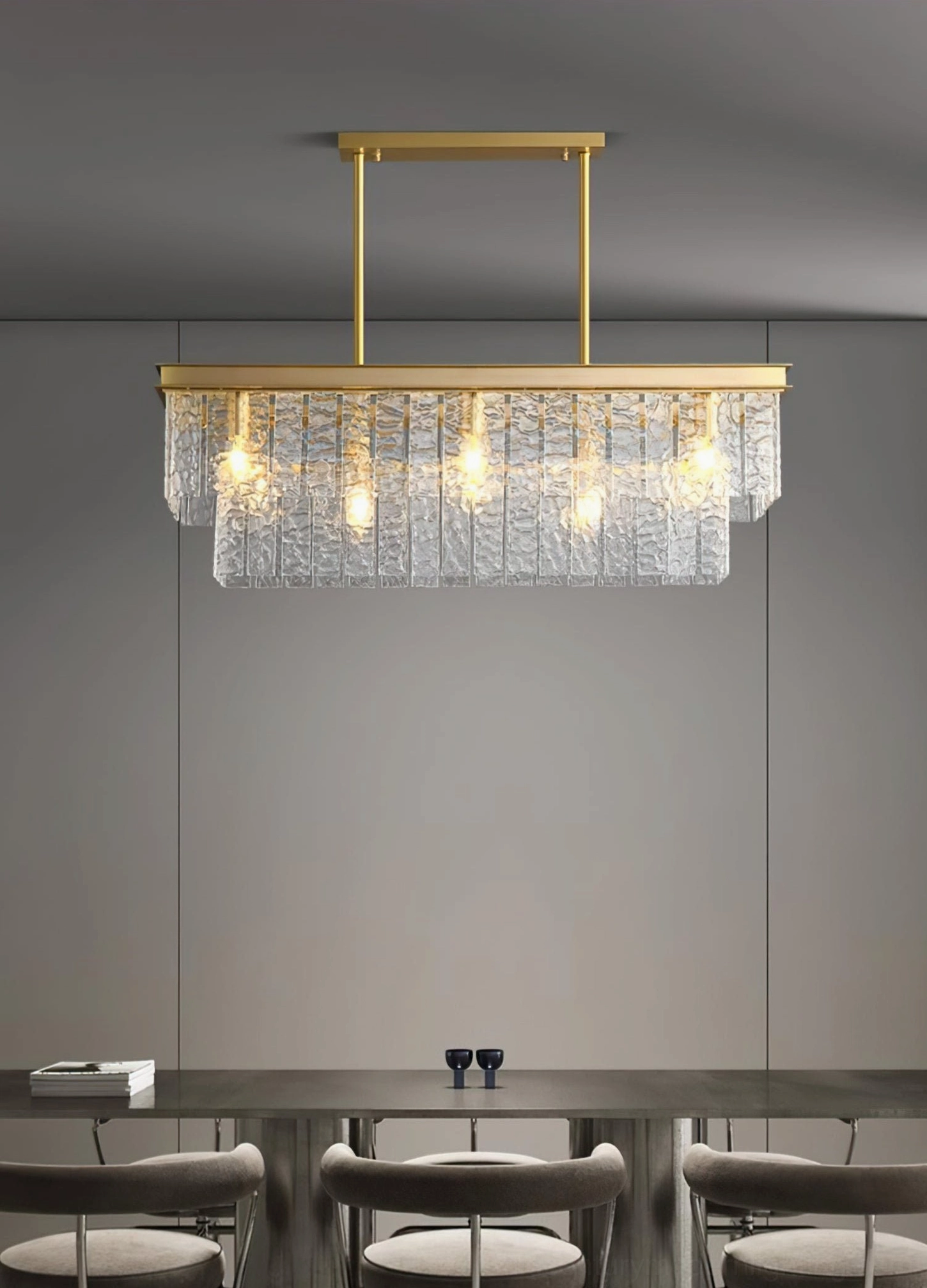 Modern tiered glass chandelier coordinates with minimalist neutral dining space and contemporary furniture