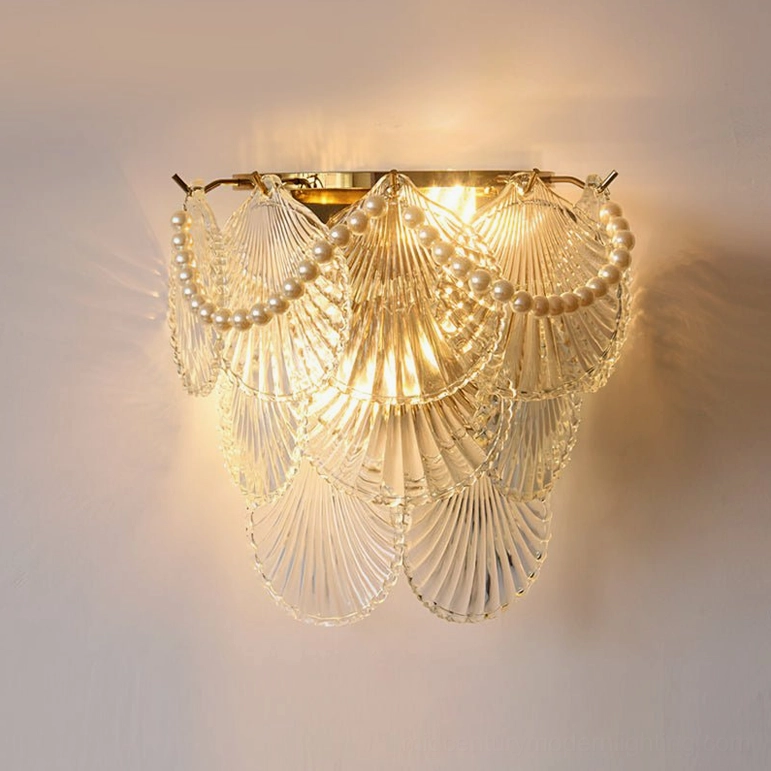 Galerie modern wall lamp with clear glass, pearl trim detail, and gold hardware, fully lit