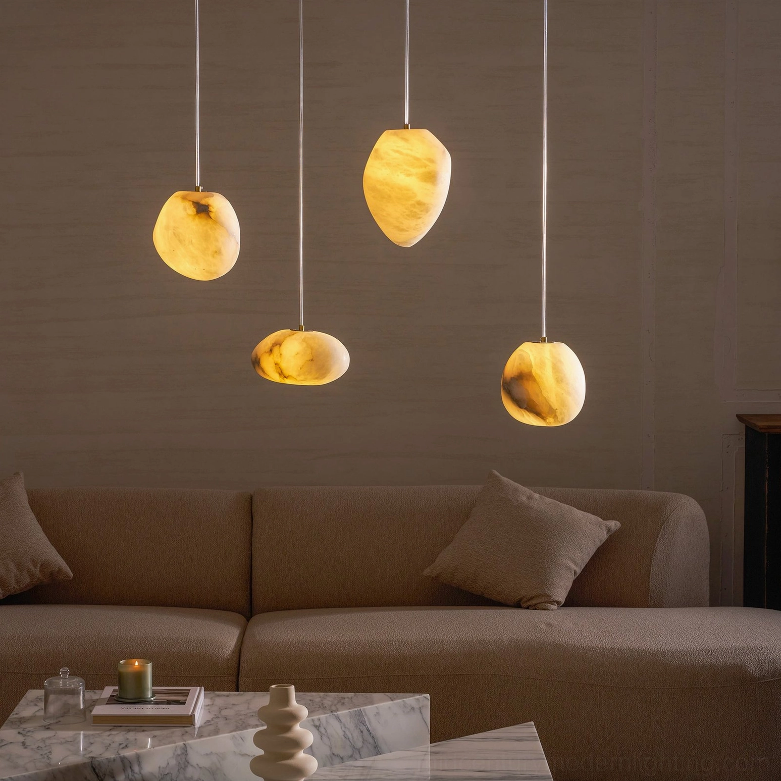 Multiple Galet alabaster pendants creating soft ambient lighting in luxury minimalist living room