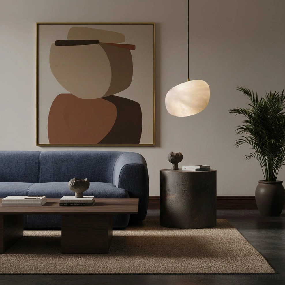 Galet alabaster pendant light above dark blue sofa with abstract wall art