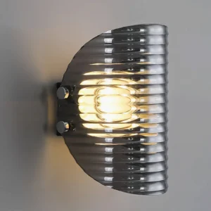 Close-up of Gatsby mid-century modern wall sconce showing chrome mounting bolts and warm glowing LED light through ribbed glass texture