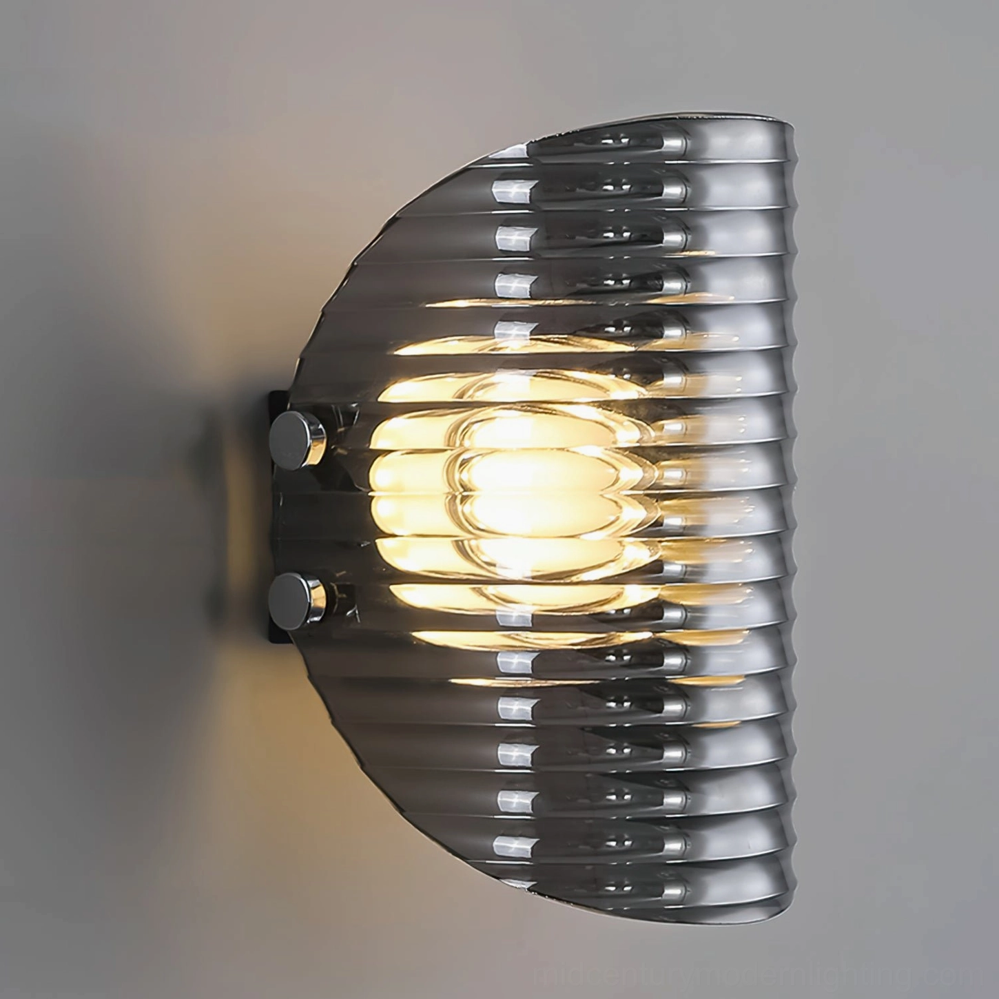 Close-up of Gatsby mid-century modern wall sconce showing chrome mounting bolts and warm glowing LED light through ribbed glass texture