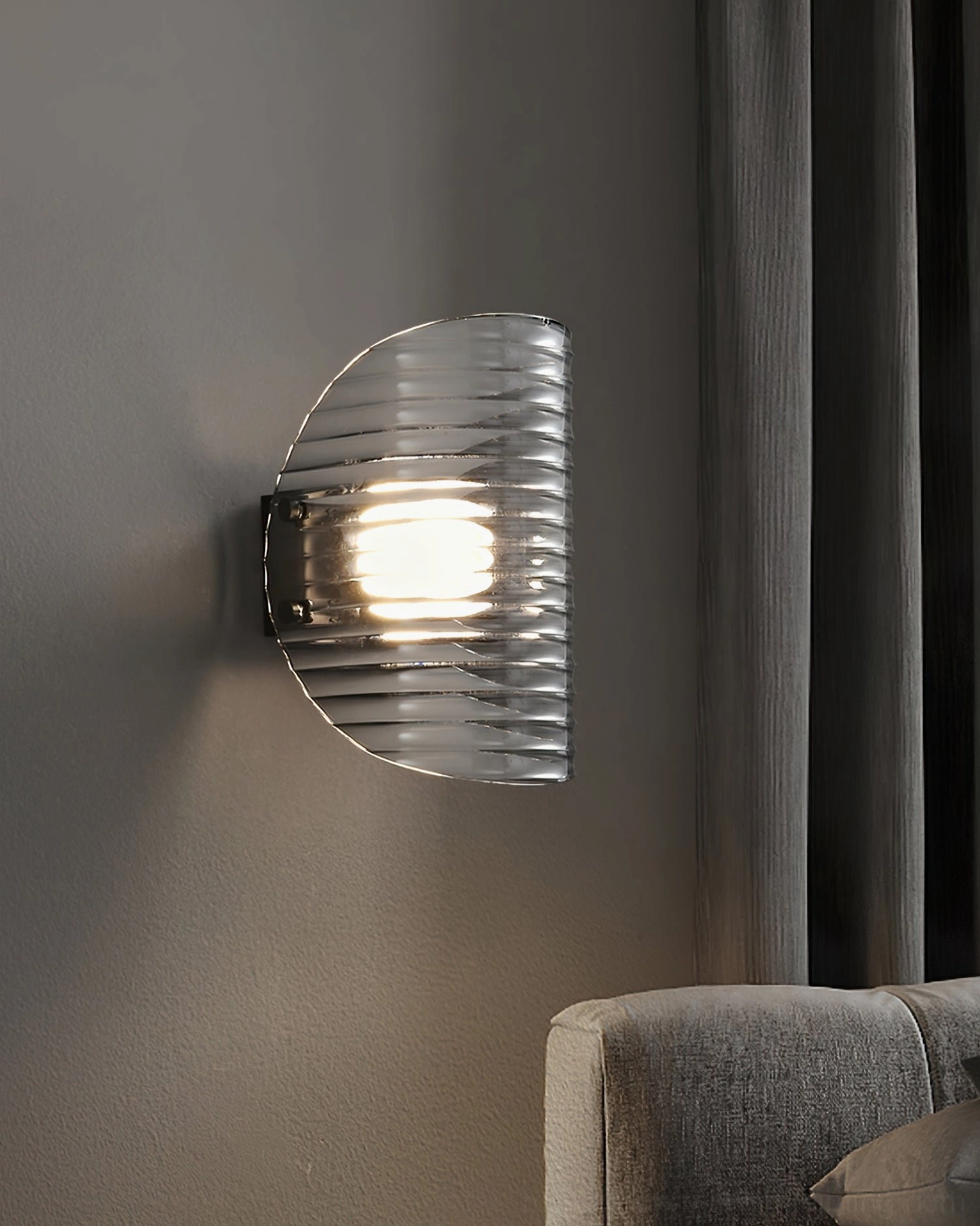 Gatsby semi-circular smoked ribbed glass wall lamp in living room with sofa and curtains, warm glowing LED light creating ambient atmosphere