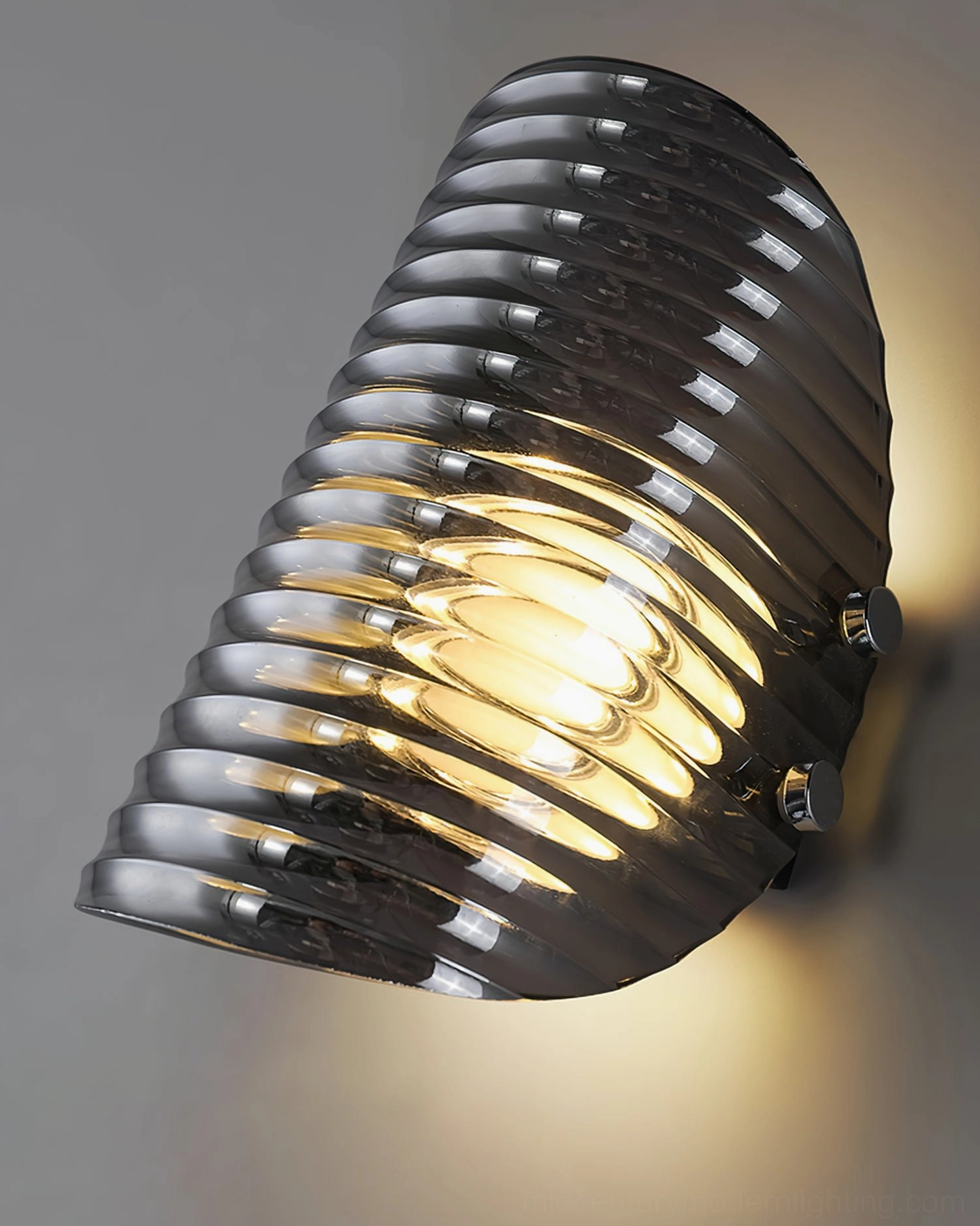Gatsby wall lamp mounted at angle showcasing side profile, smoked ribbed glass with warm ambient backlight and polished metal hardware