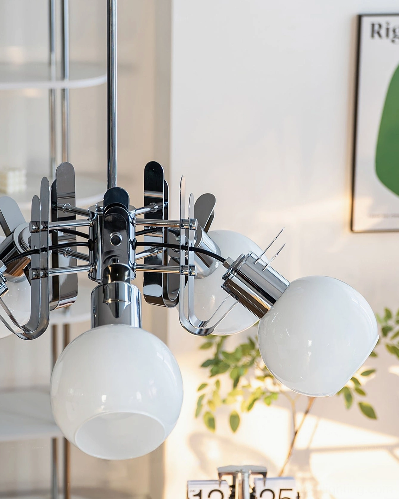 Close-up detail of geometric chandelier chrome hardware and milky white glass globe components