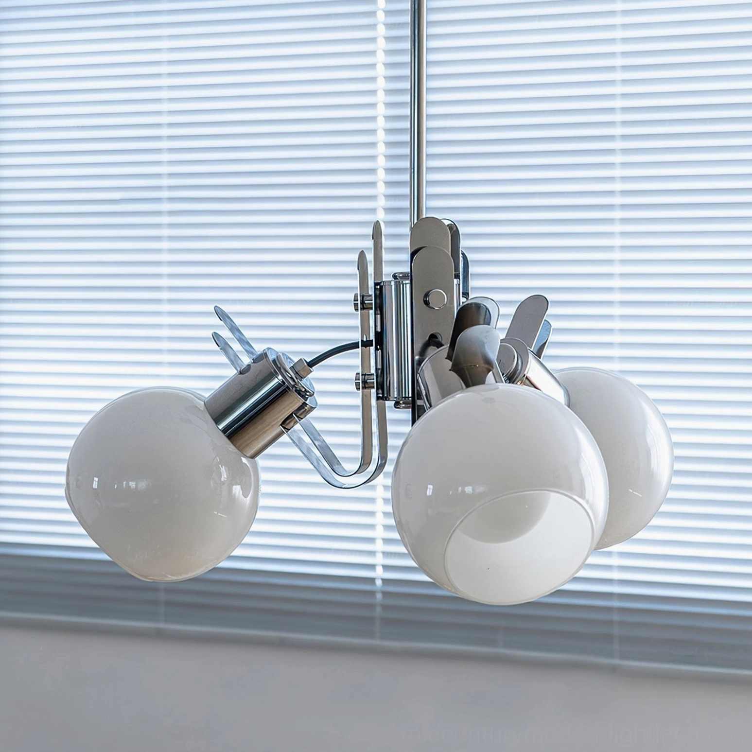 Polished chrome geometric glass chandelier showing multiple lamp head configuration and light distribution