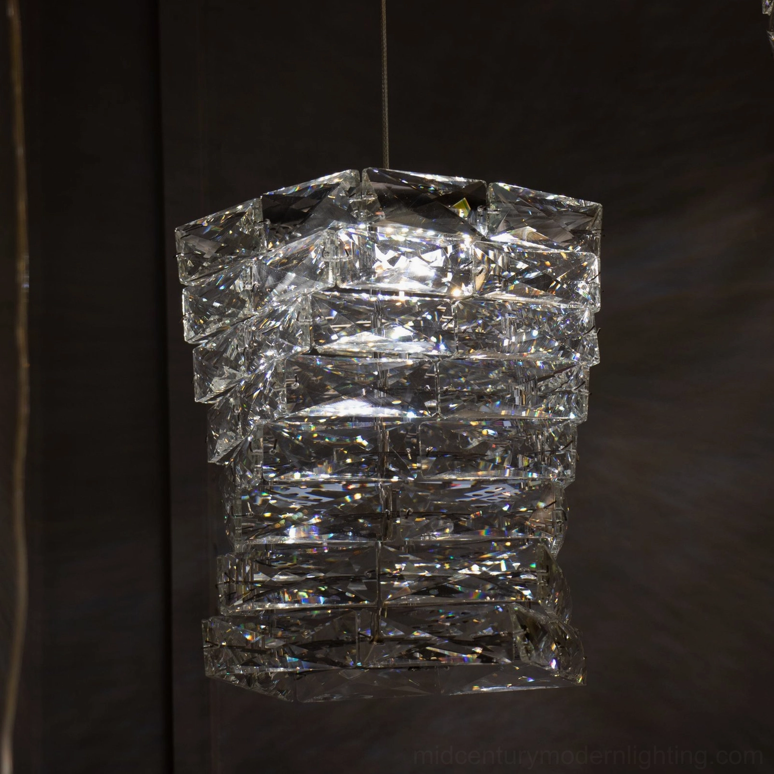 Single geometric faceted crystal pendant light with soft warm glow suitable for modern interior spaces