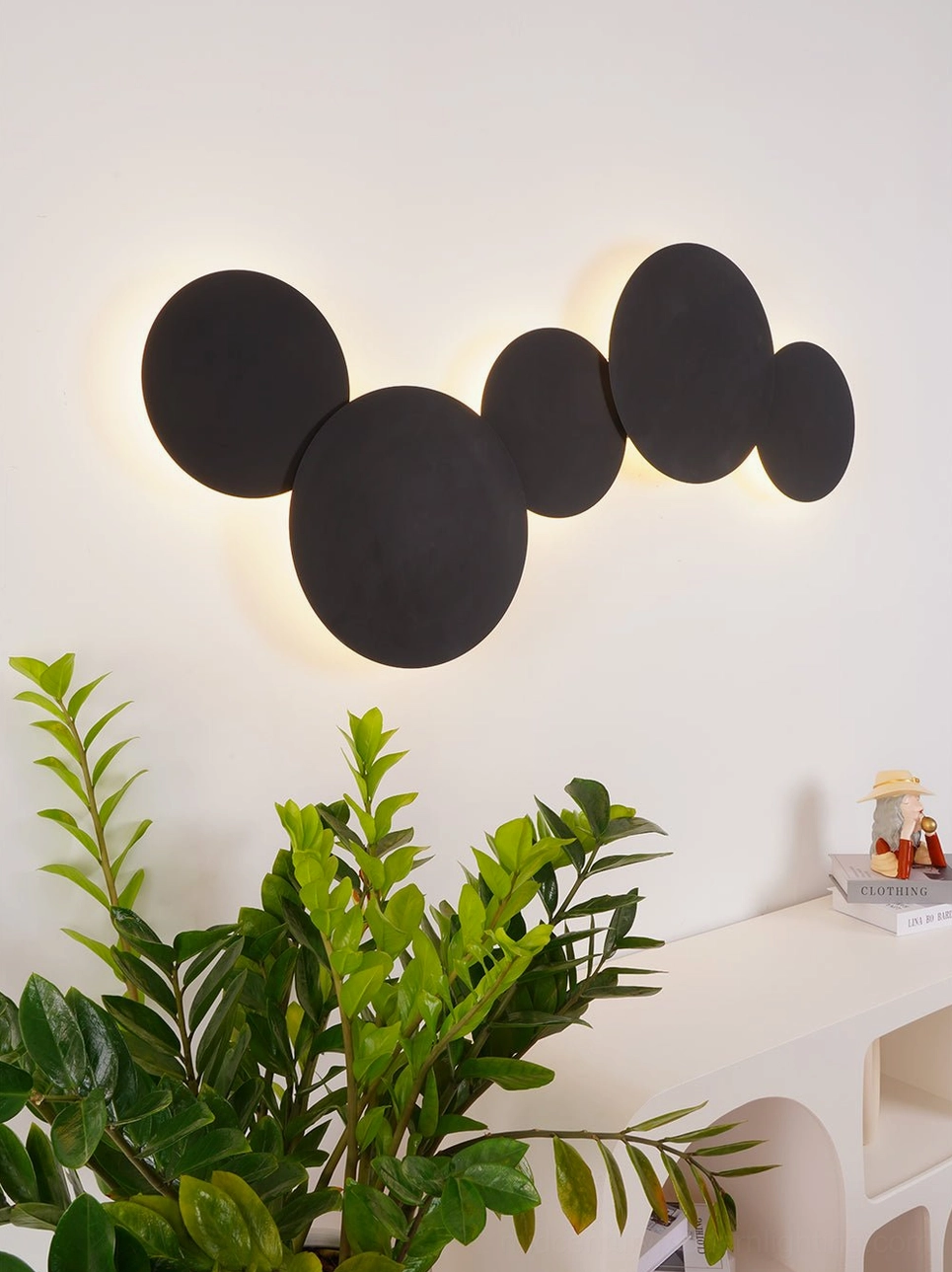 Geometric disc wall sconce with three-dimensional circular form creating dynamic interplay of illumination and shadow