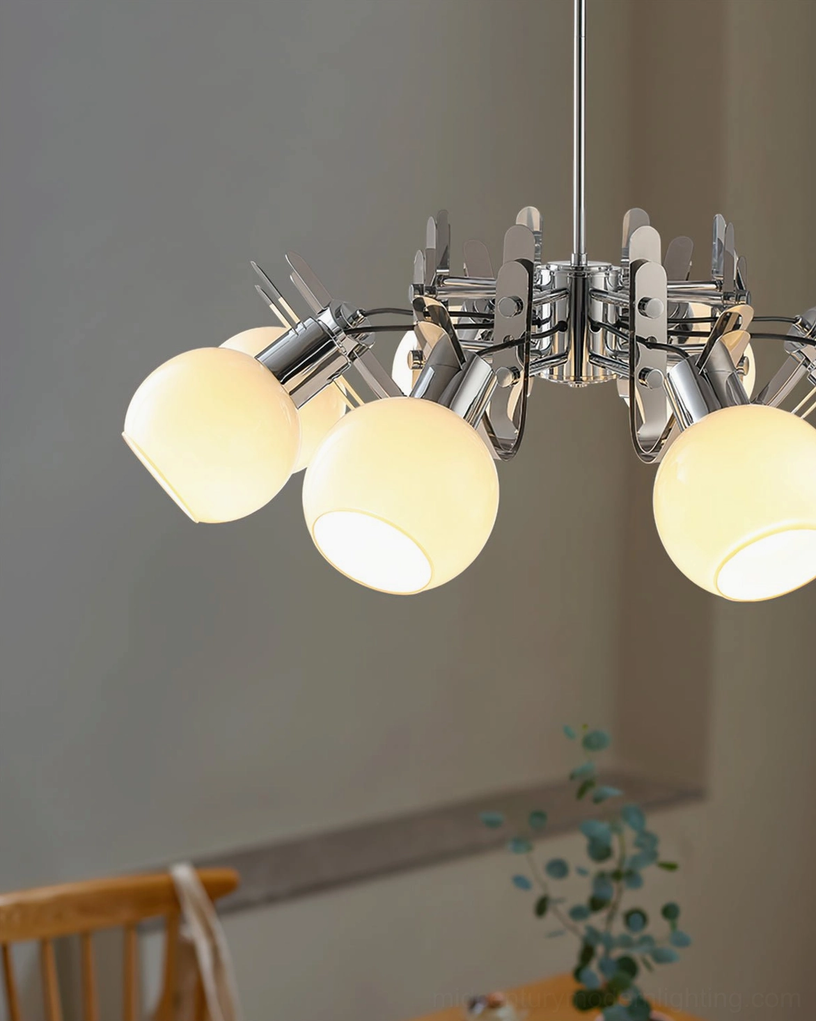 Contemporary geometric glass chandelier installation in home foyer with ambient ceiling lighting
