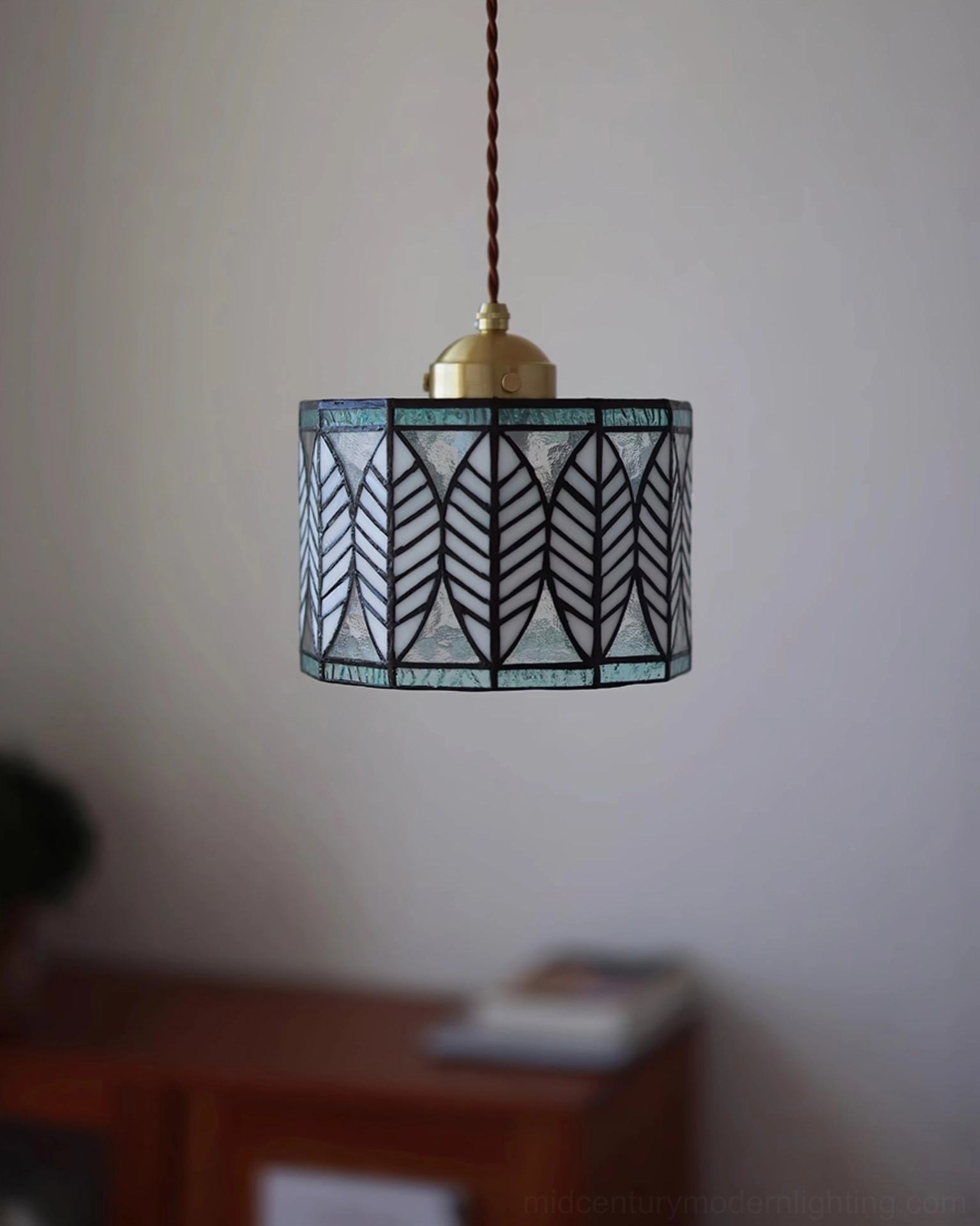 Geometric leaf pattern Tiffany pendant with brass mounting, mid-century modern lighting aesthetic