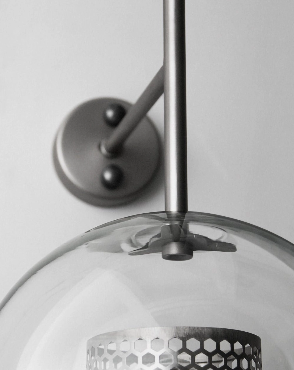 Modern glass wall sconce with metal hardware and clean geometric proportions