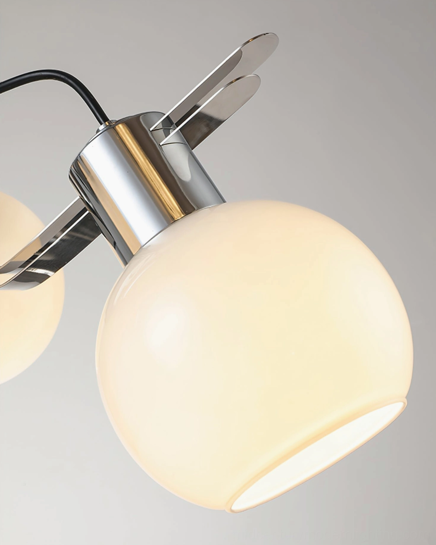 Illuminated geometric opal glass shade showing warm light diffusion through chrome base mount