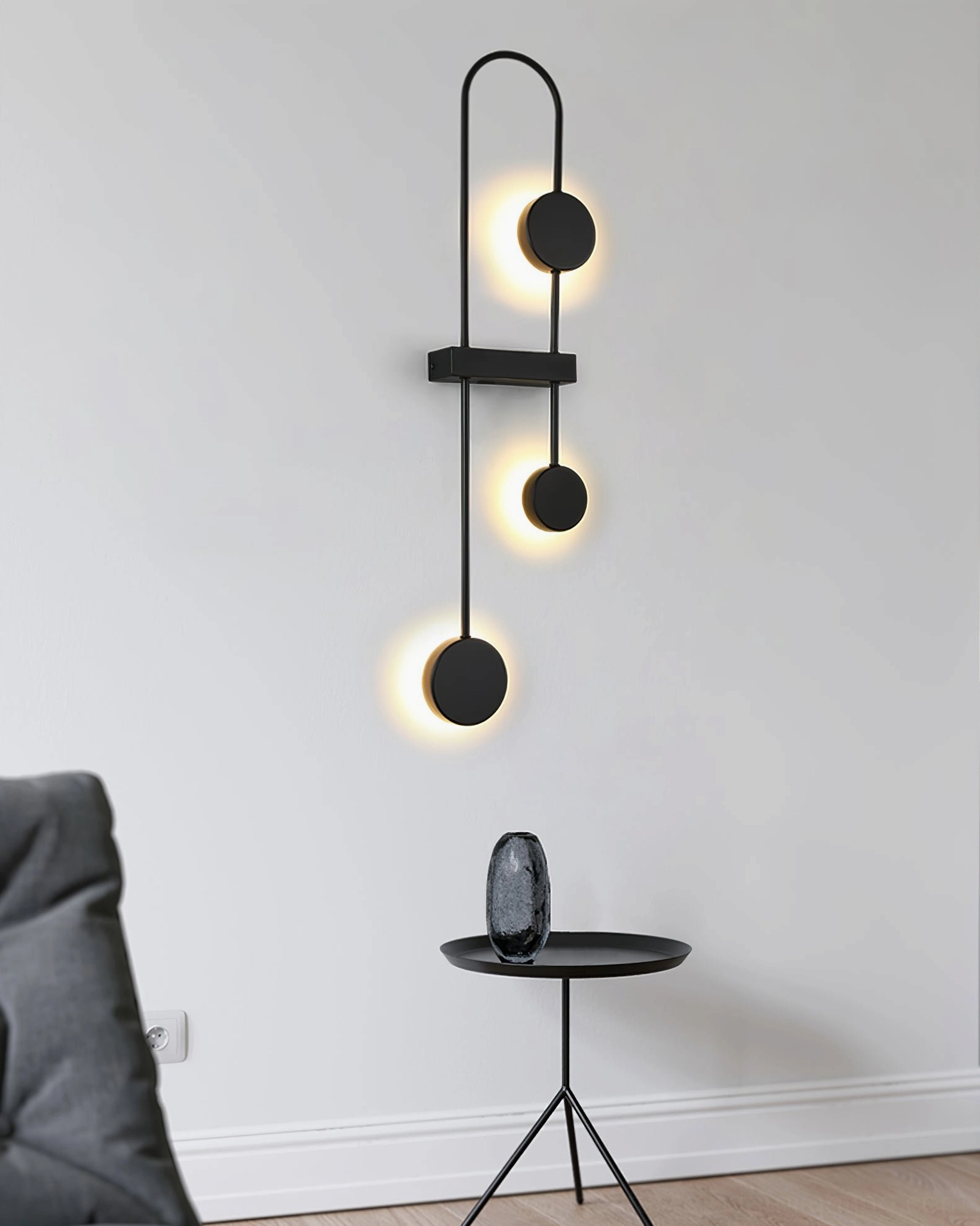 Modern geometric wall sconce with stacked spherical pendants creating artistic light composition