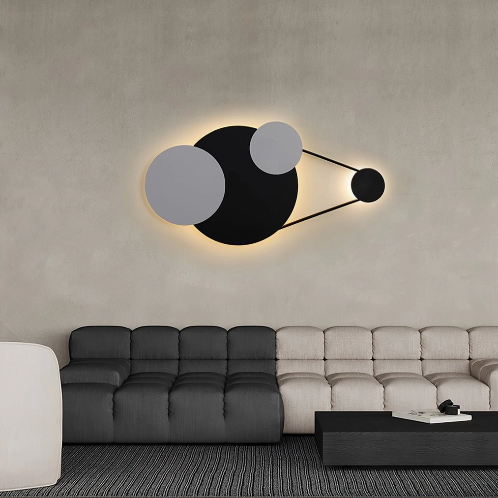 Vertical Trio wall lamp installed in contemporary living room above sectional sofa with ambient warm glow