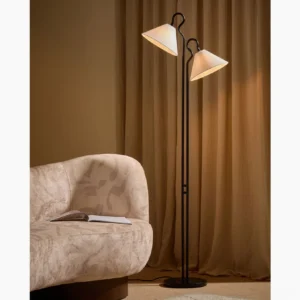 Gerardo arc floor lamp three-quarter view in warm living room with curved sofa warm ambient lighting mid-century modern