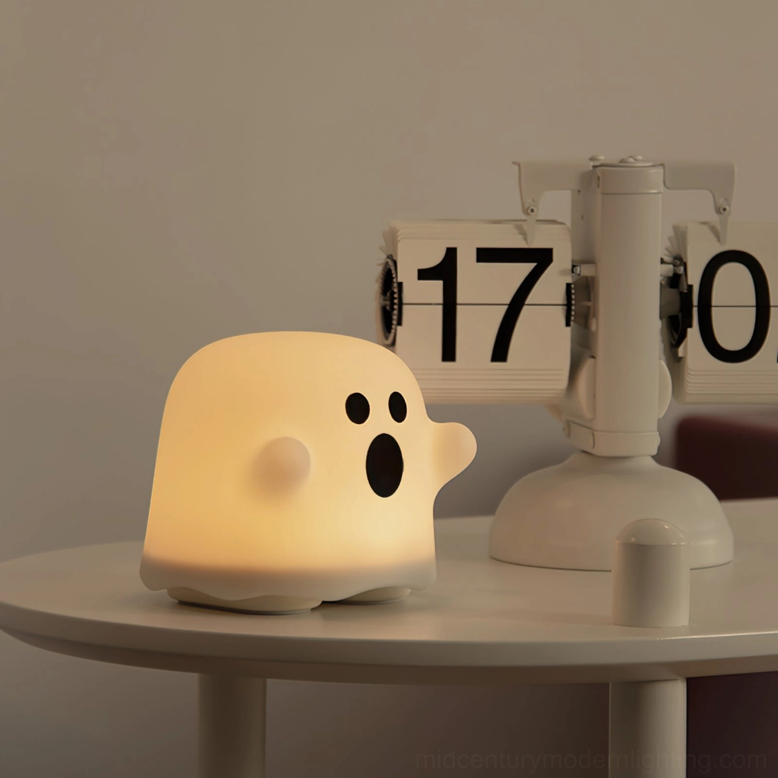 Small ghost night light three-quarter view glowing warm light on compact bedroom side table