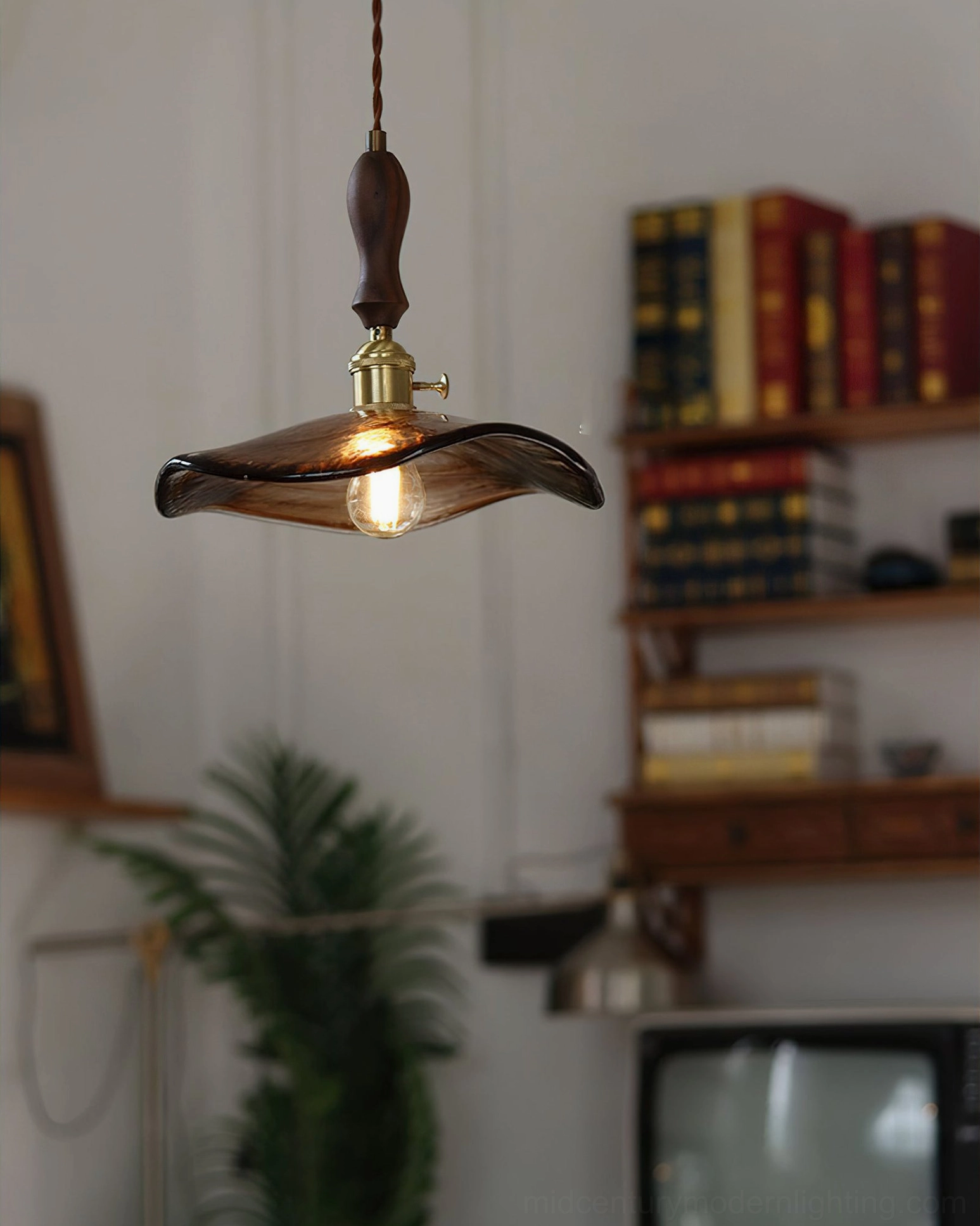 Side profile of Gideon vintage pendant light with twisted fabric cord suspended in retro study with bookshelf and antique television