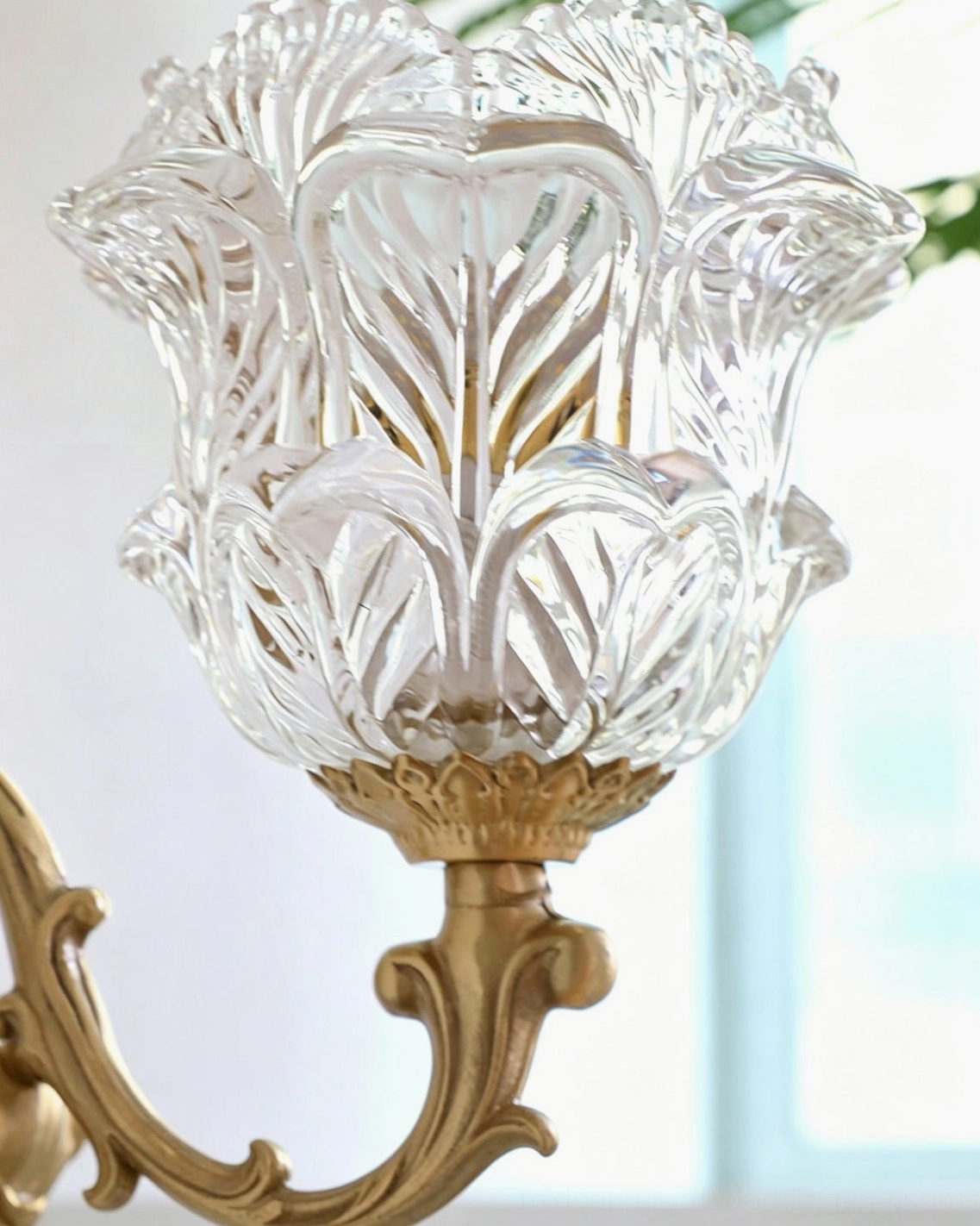 Detail shot of Gideon tulip glass shade showing floral leaf texture and clear crystal glass against indoor window backdrop