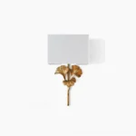Gingko leaf vintage wall sconce with brass frame and white fabric shade on clean background