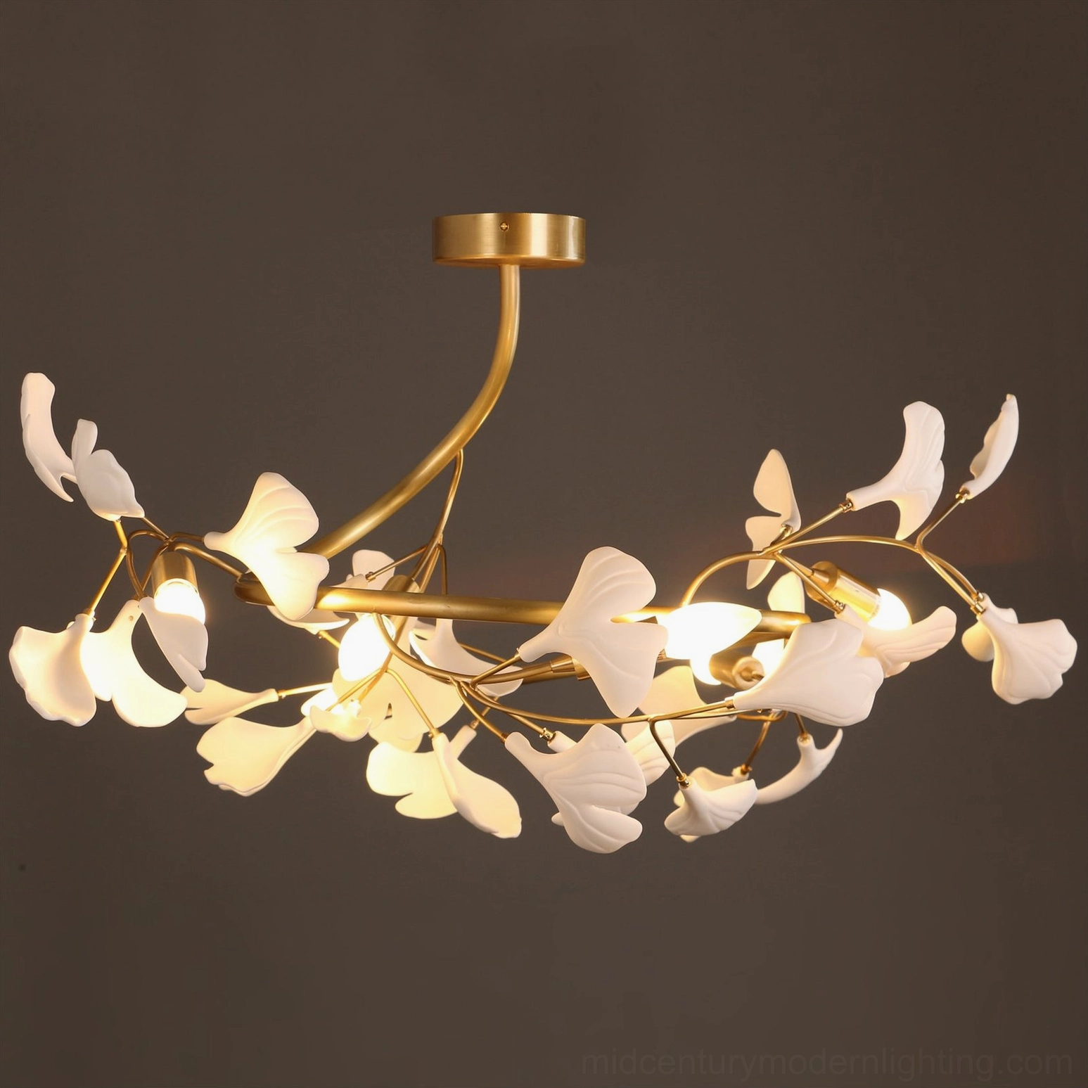 Ginkgo ceiling lamp with warm lighting showing brass patina and white ceramic leaf finish