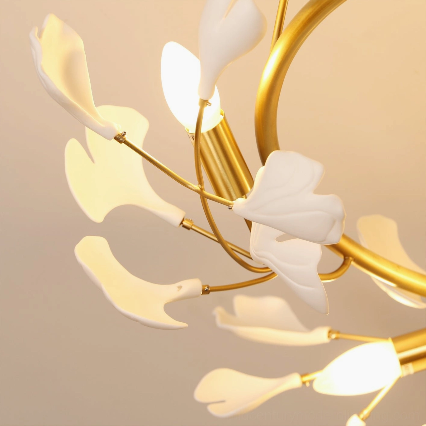 Low angle view of ginkgo ceiling lamp highlighting curved brass arms and illuminated bulb