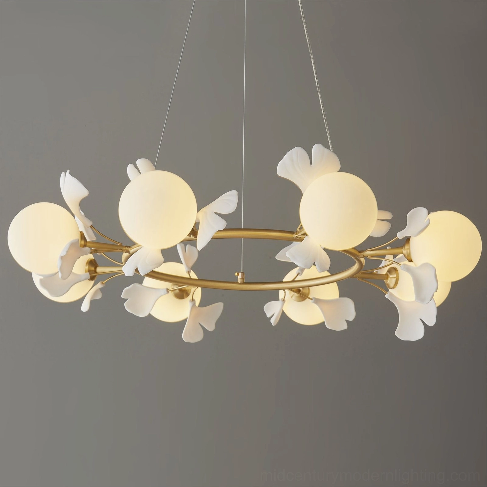 Close-up detail of brass arms and frosted glass spheres on ginkgo chandelier