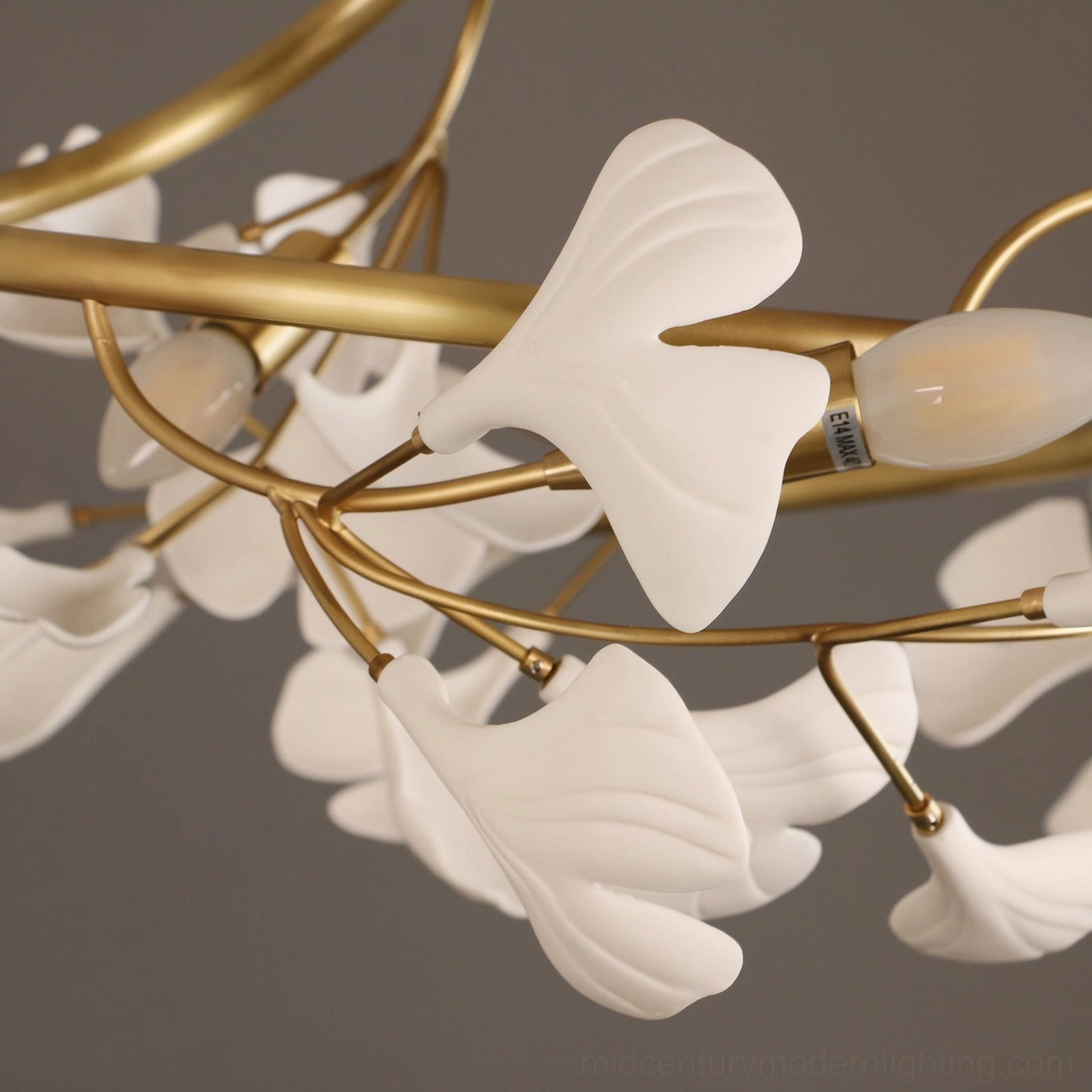 Macro close-up of ginkgo lamp showing textured matte white leaves and brass wiring