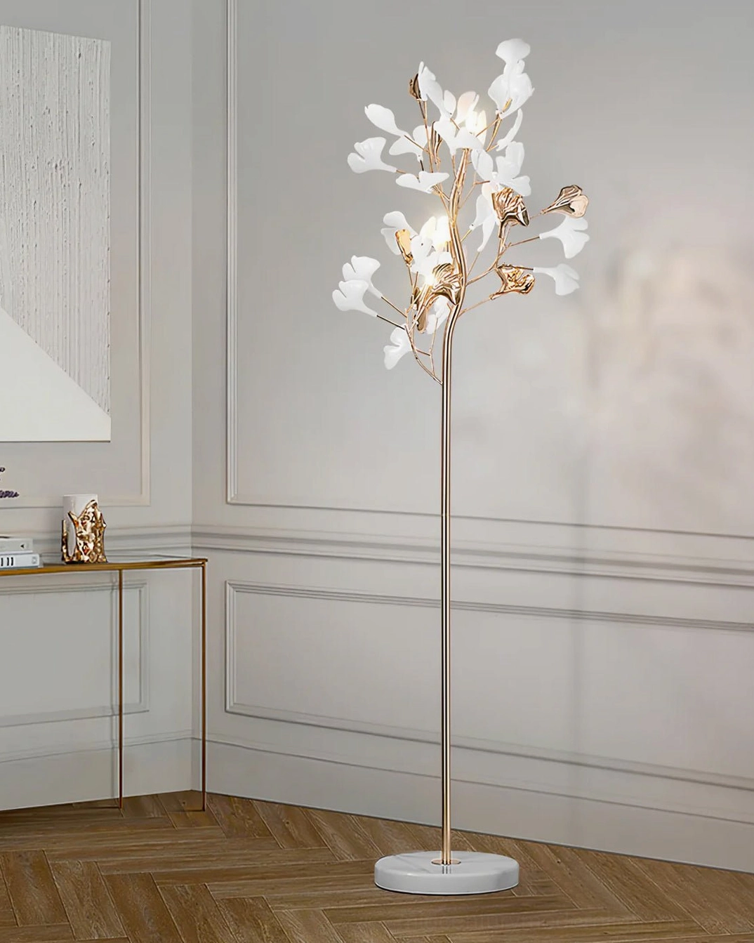 Ginkgo Leaf Floor Lamp with white marble base in neutral bedroom setting, polished gold metal stem, architectural sculptural presence
