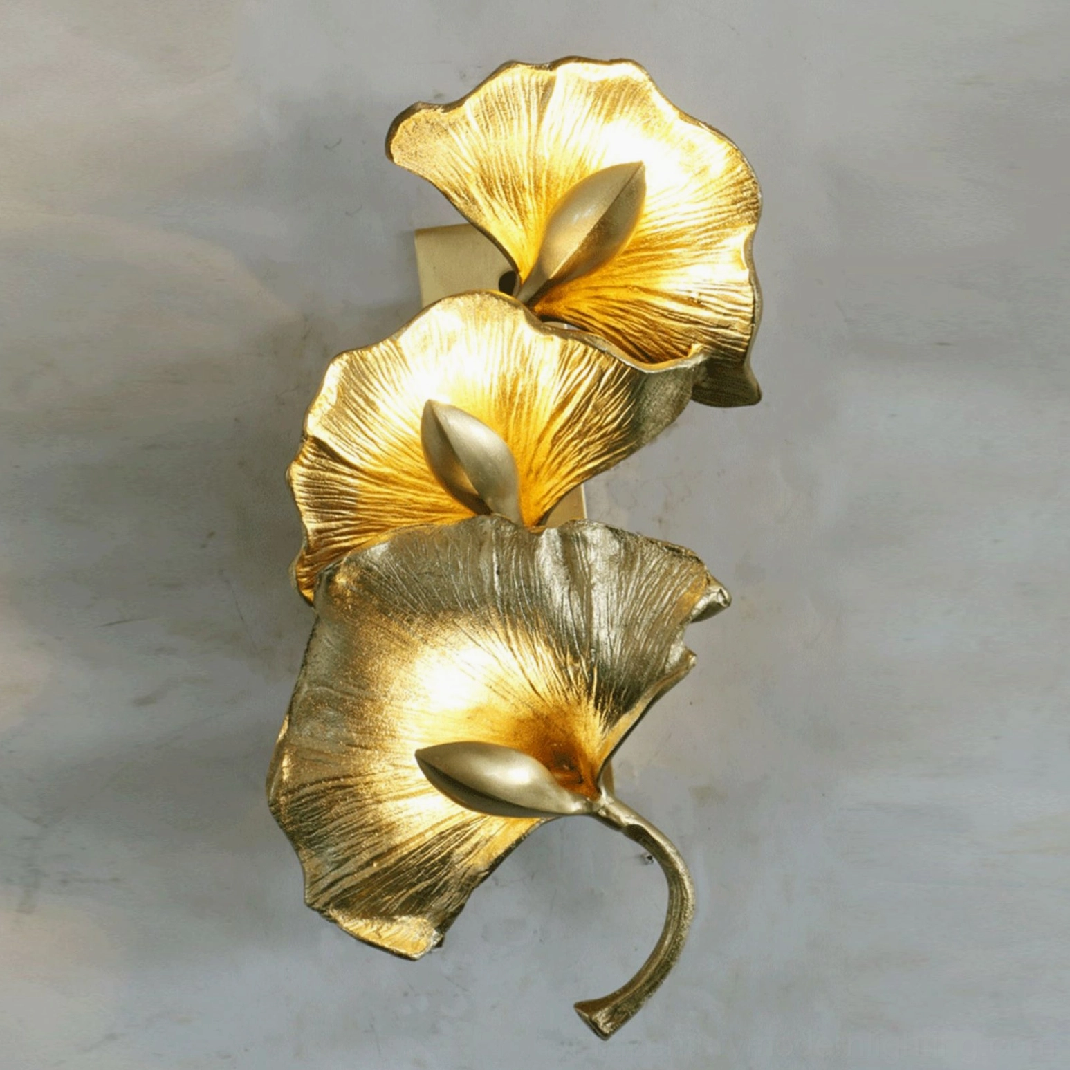 Ginkgo leaf wall lamp side view warm illuminated light detailed leaf veins concrete background