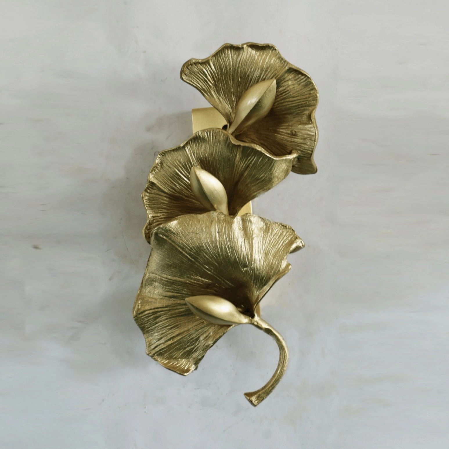 Ginkgo leaf wall sconce three vertical brass gold leaves light gray wall botanical design