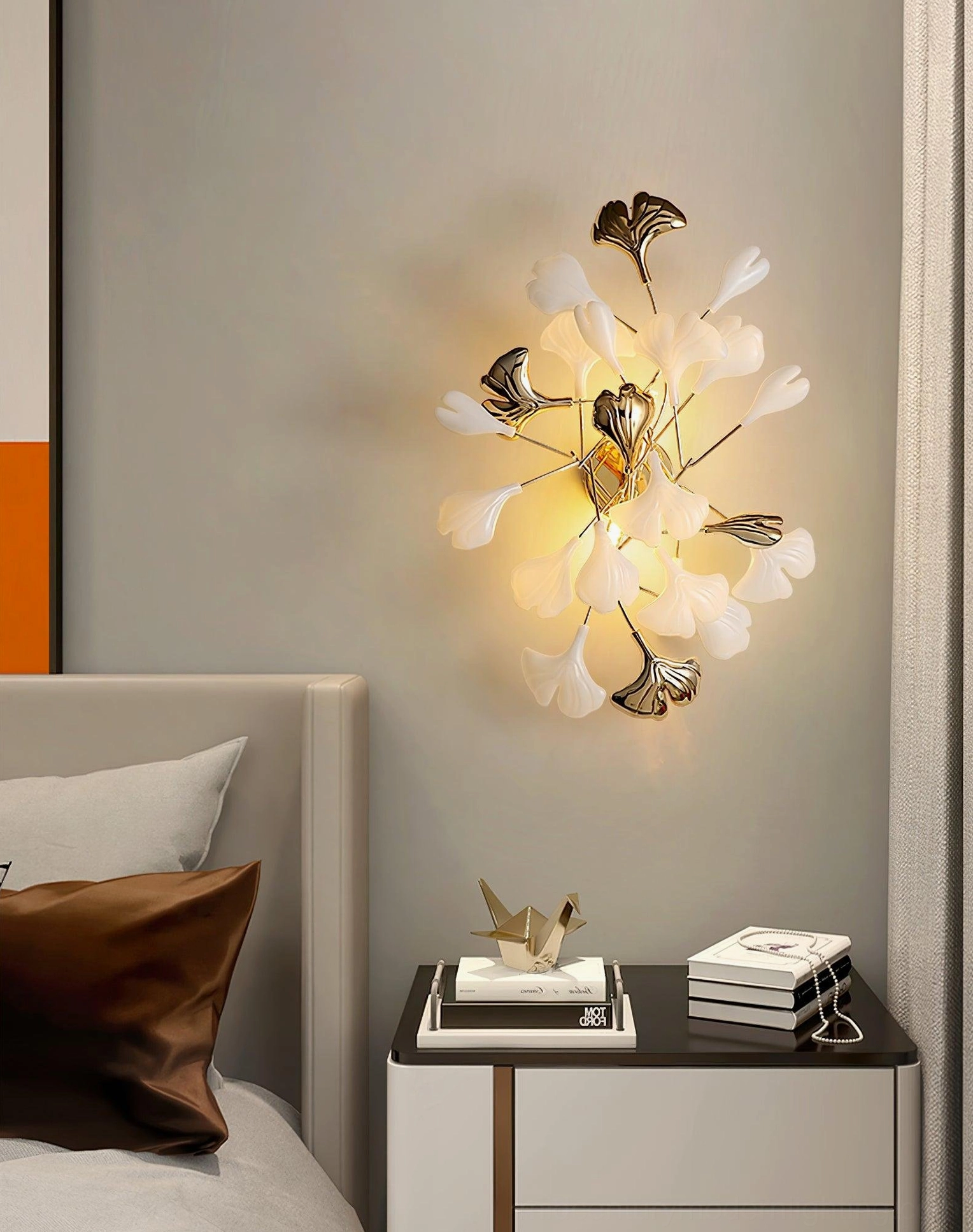 Ginkgo leaf sconce warm light illumination, close studio view, gold metalwork, ceramic leaf silhouette
